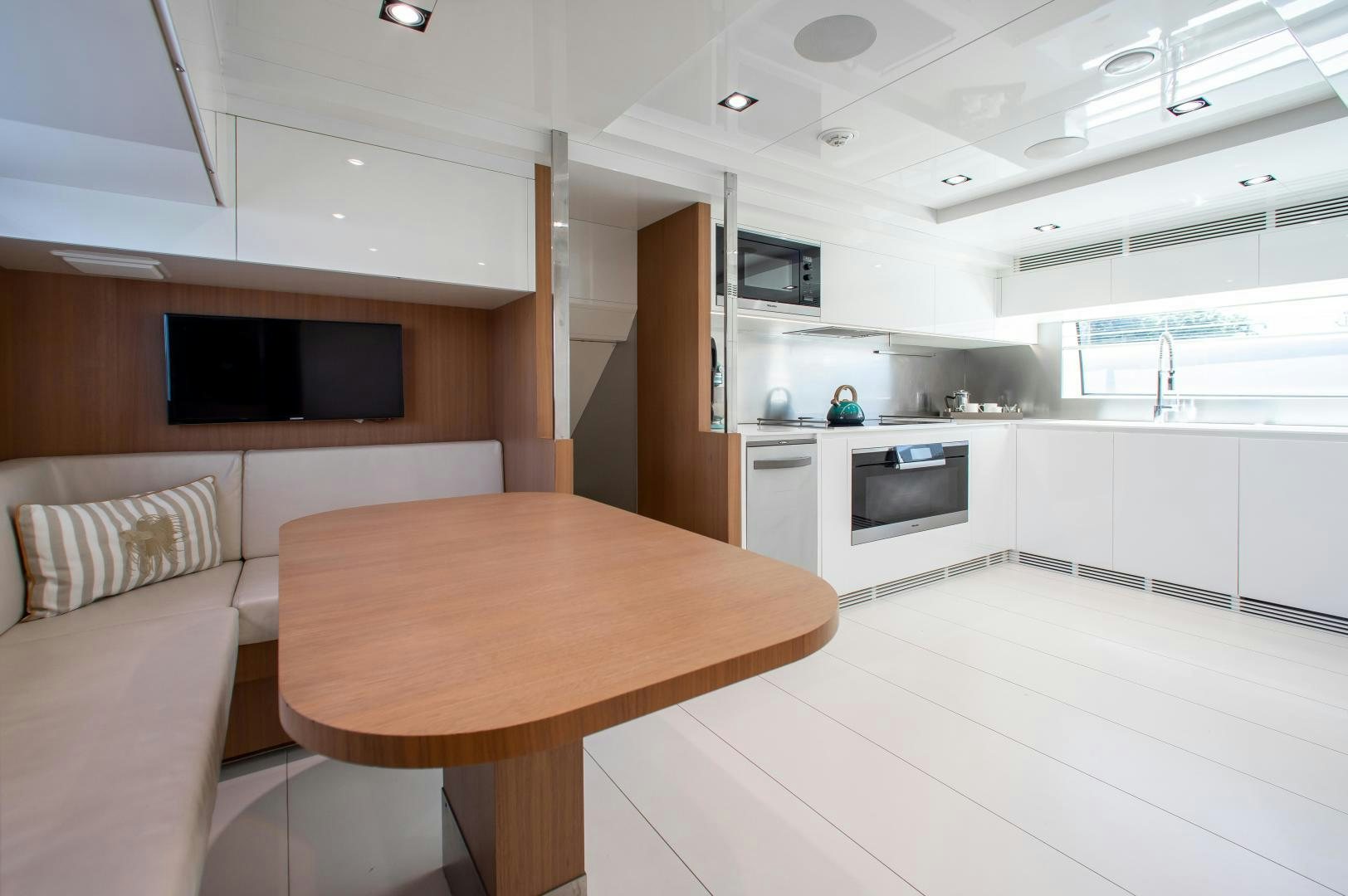 a kitchen with a table and couch aboard CHOP CHOP Yacht for Sale
