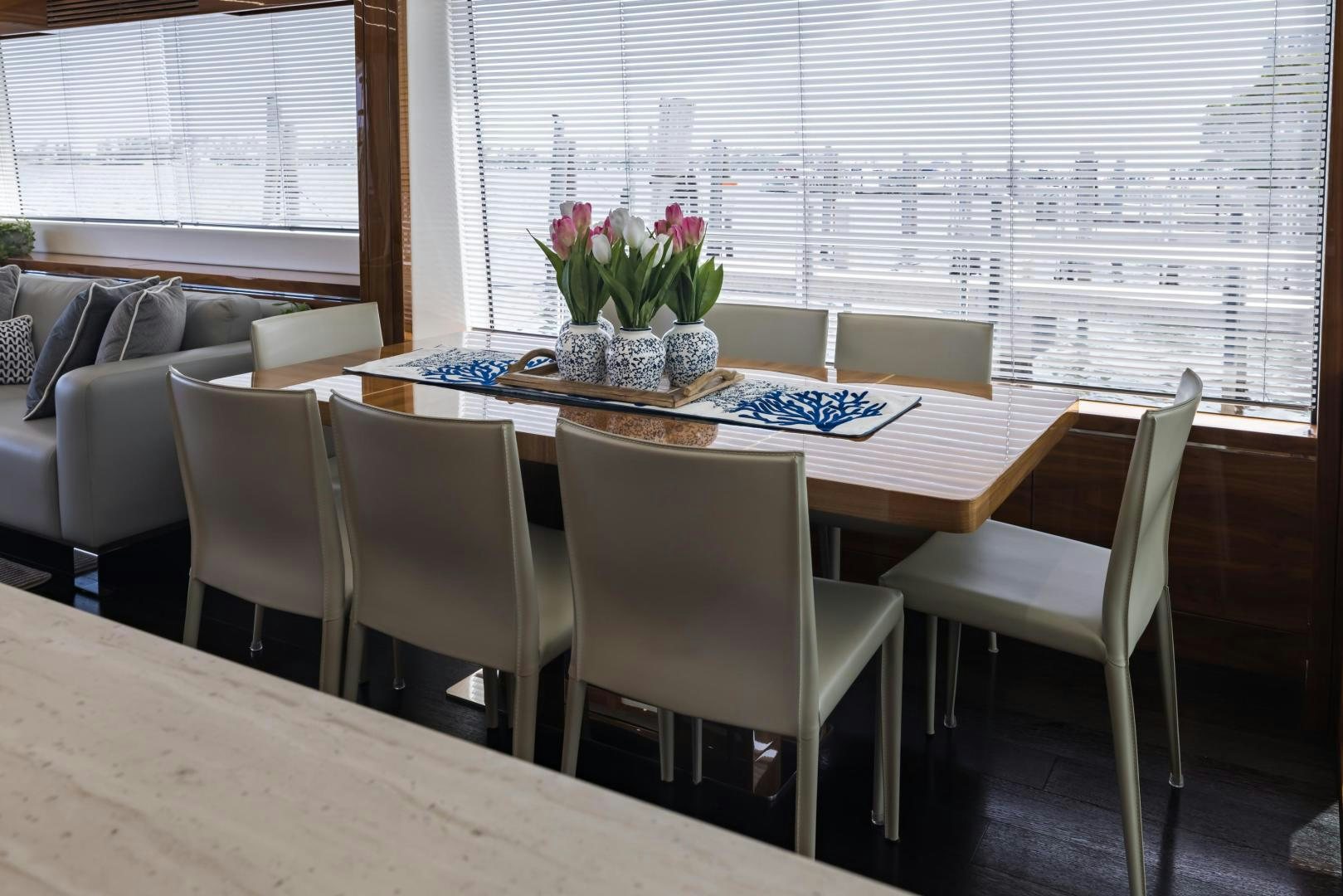 a dining table with chairs and a couch in the background aboard MR. G Yacht for Sale
