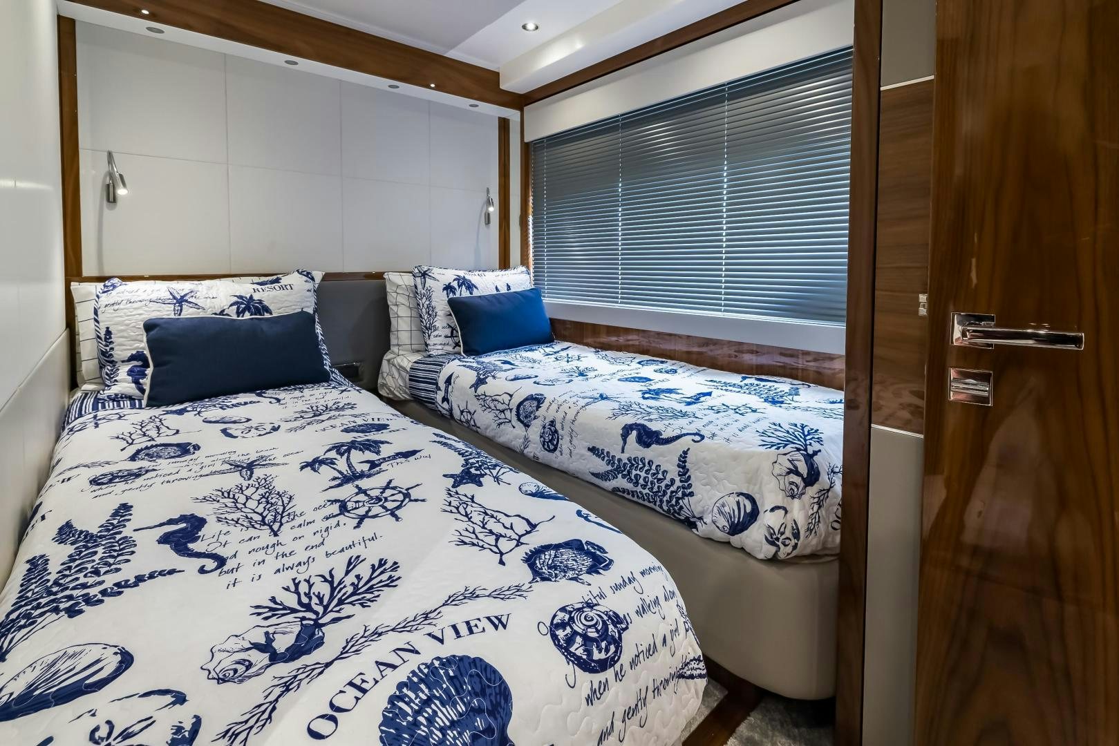 a bed with blue and white sheets aboard MR. G Yacht for Sale