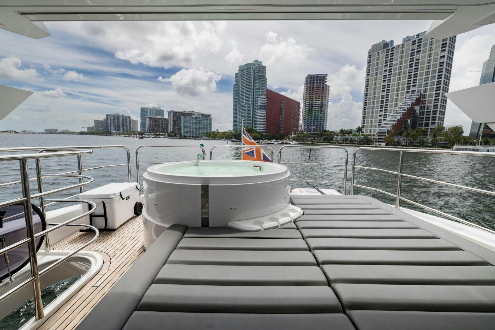 a deck with a view of a city and a body of water aboard MR. G Yacht for Sale