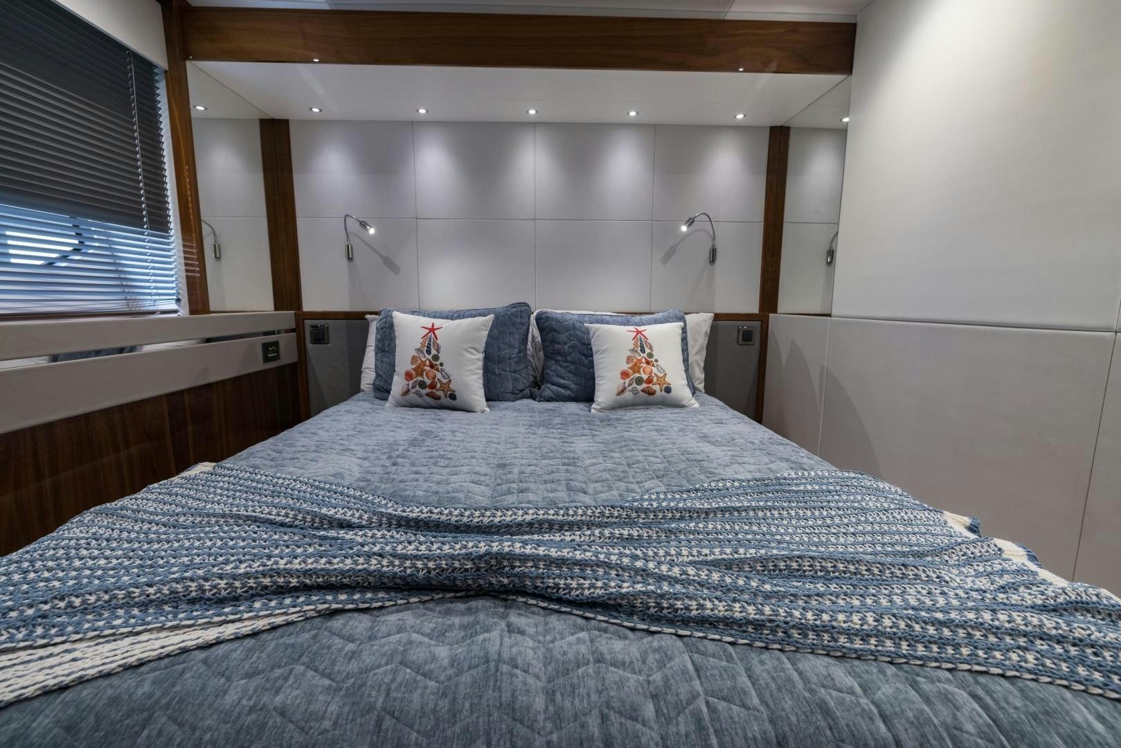 a bed with a blue comforter aboard MR. G Yacht for Sale