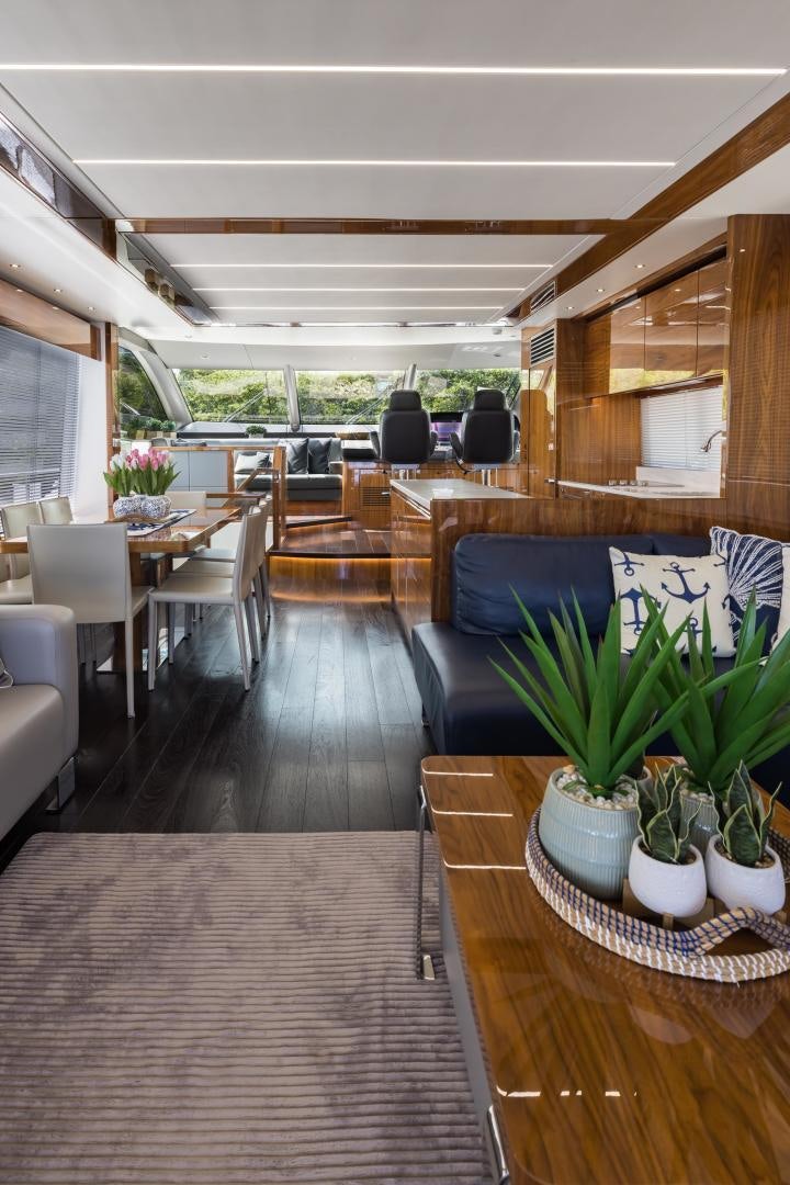 a large room with a wood floor and a table with chairs and plants aboard MR. G Yacht for Sale