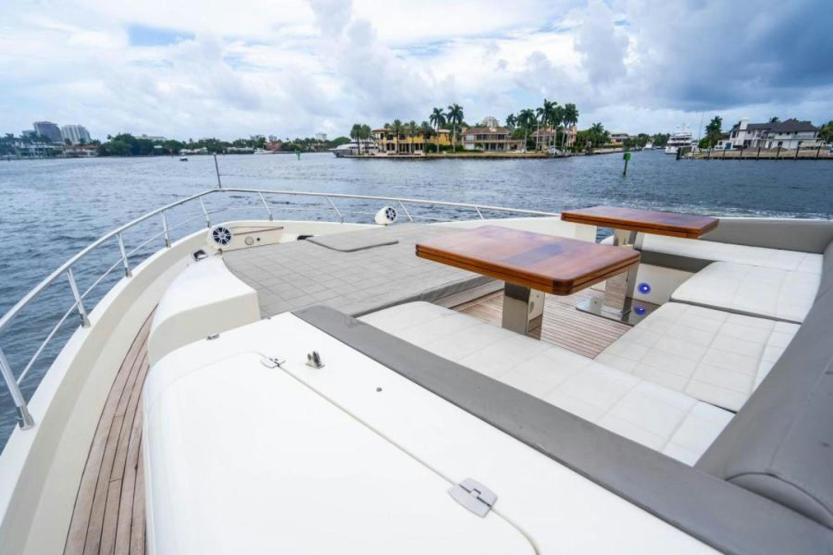 a deck with a table and chairs on it by the water aboard KNOT WOKE Yacht for Sale