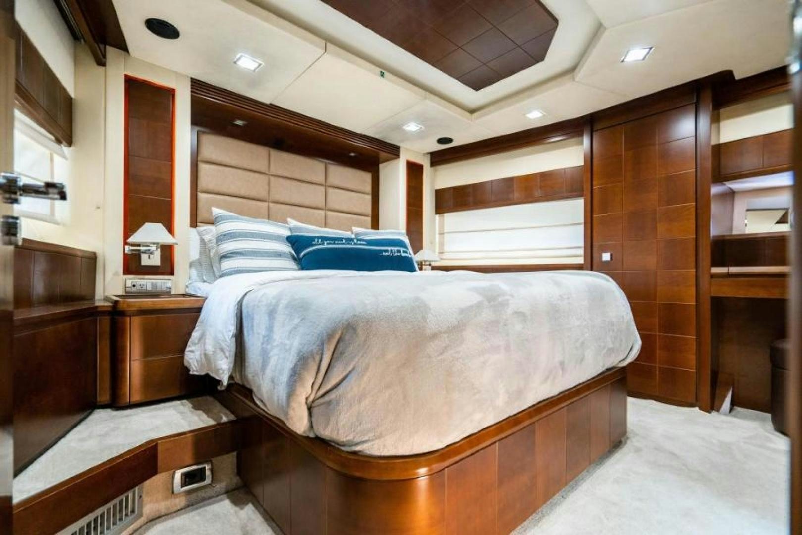 a bedroom with a bed and a wood cabinet aboard KNOT WOKE Yacht for Sale