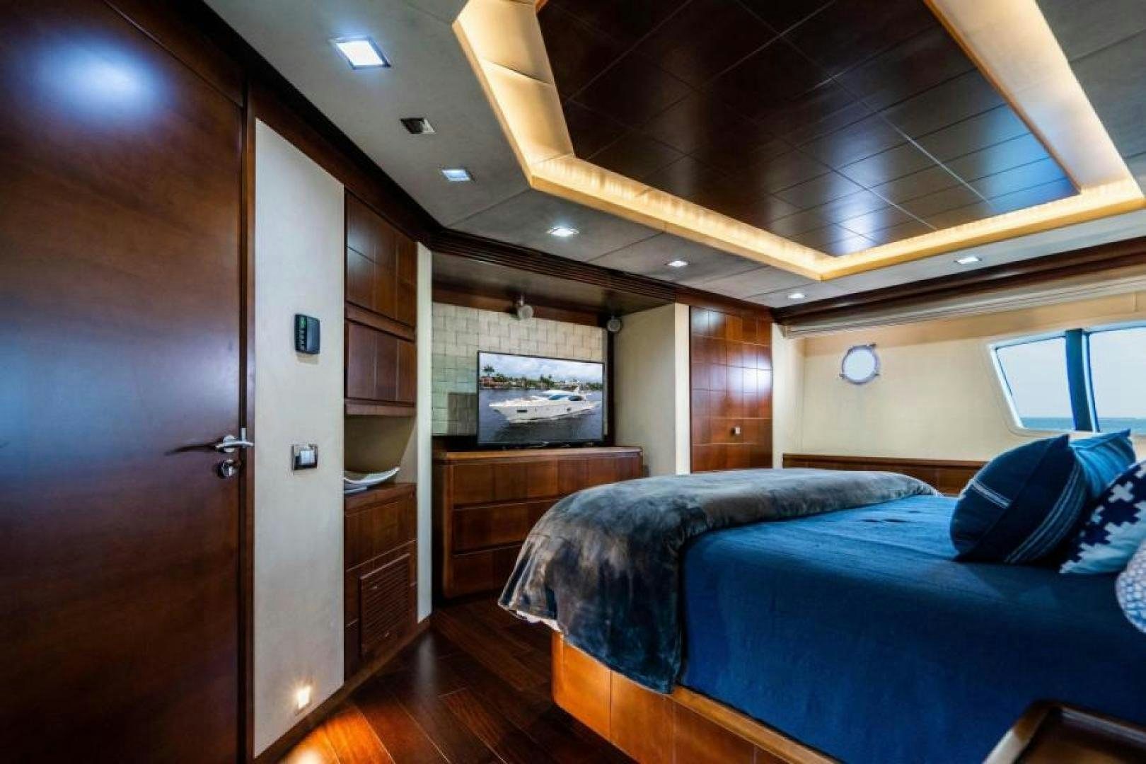 a bedroom with a bed and a wood door aboard KNOT WOKE Yacht for Sale