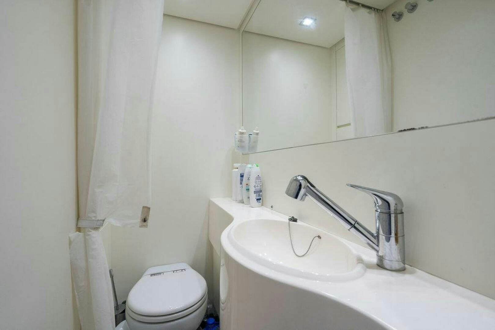 a bathroom with a toilet sink and a mirror aboard VIDI Yacht for Sale