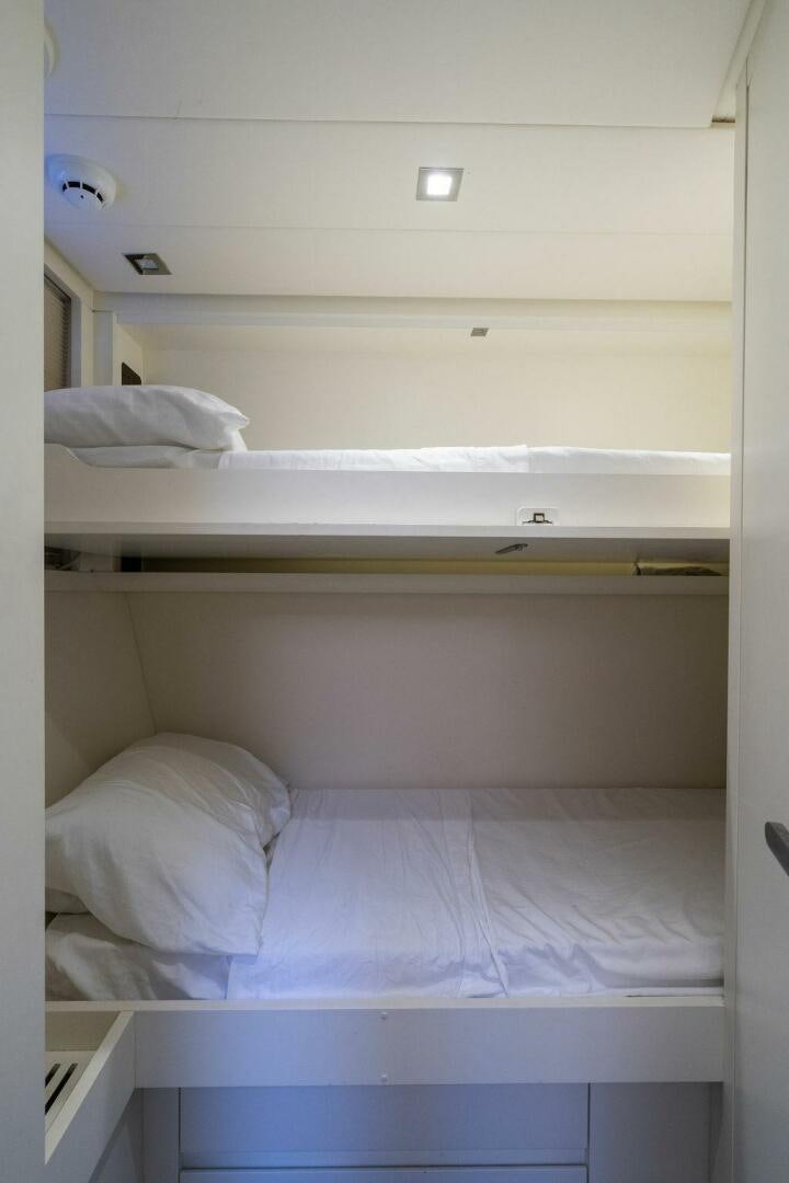 a white room with white bedding aboard VIDI Yacht for Sale