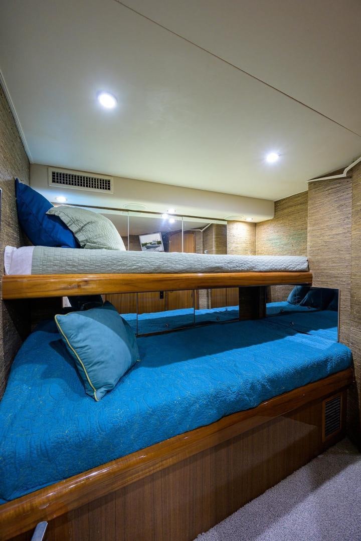 a bed with a blue comforter aboard LA LADY Yacht for Sale