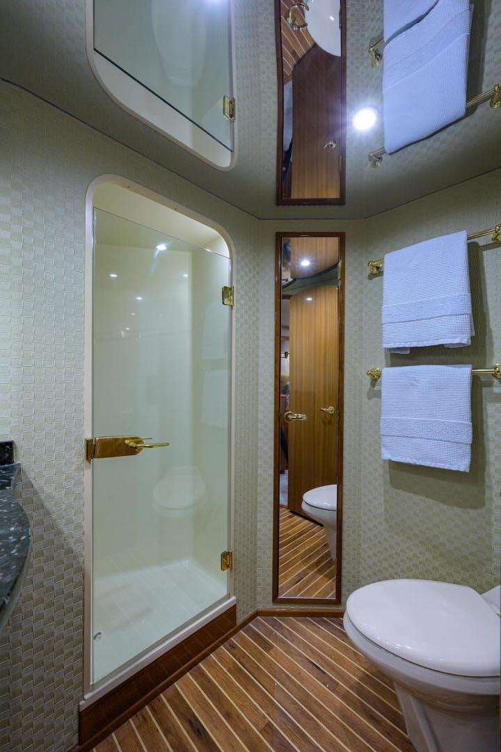 a bathroom with a glass shower door aboard LA LADY Yacht for Sale