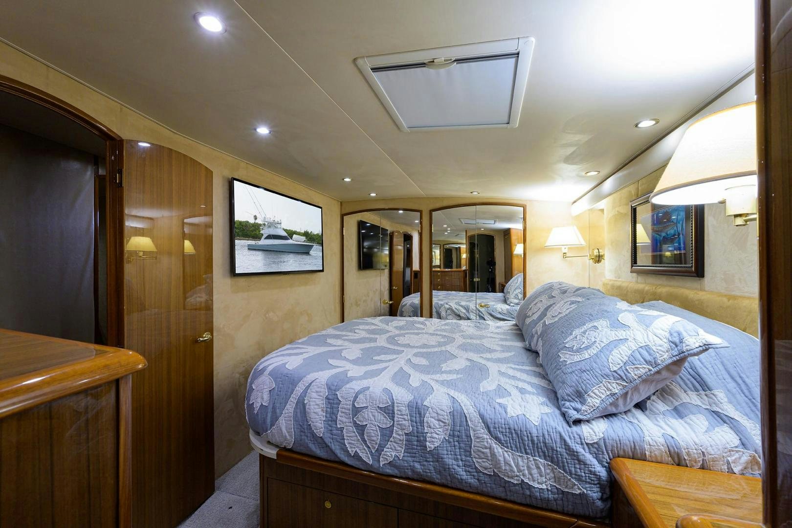a bedroom with a bed and a wood door aboard LA LADY Yacht for Sale