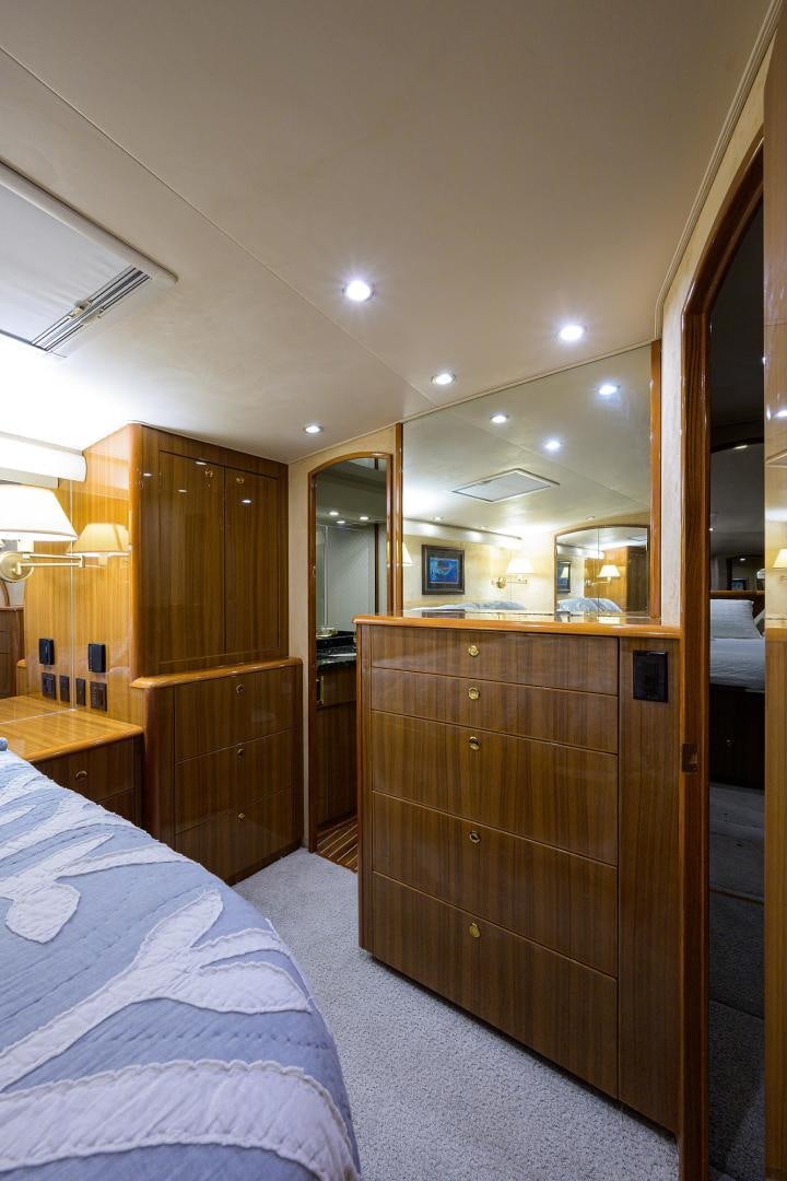 a bedroom with a bed and a closet aboard LA LADY Yacht for Sale