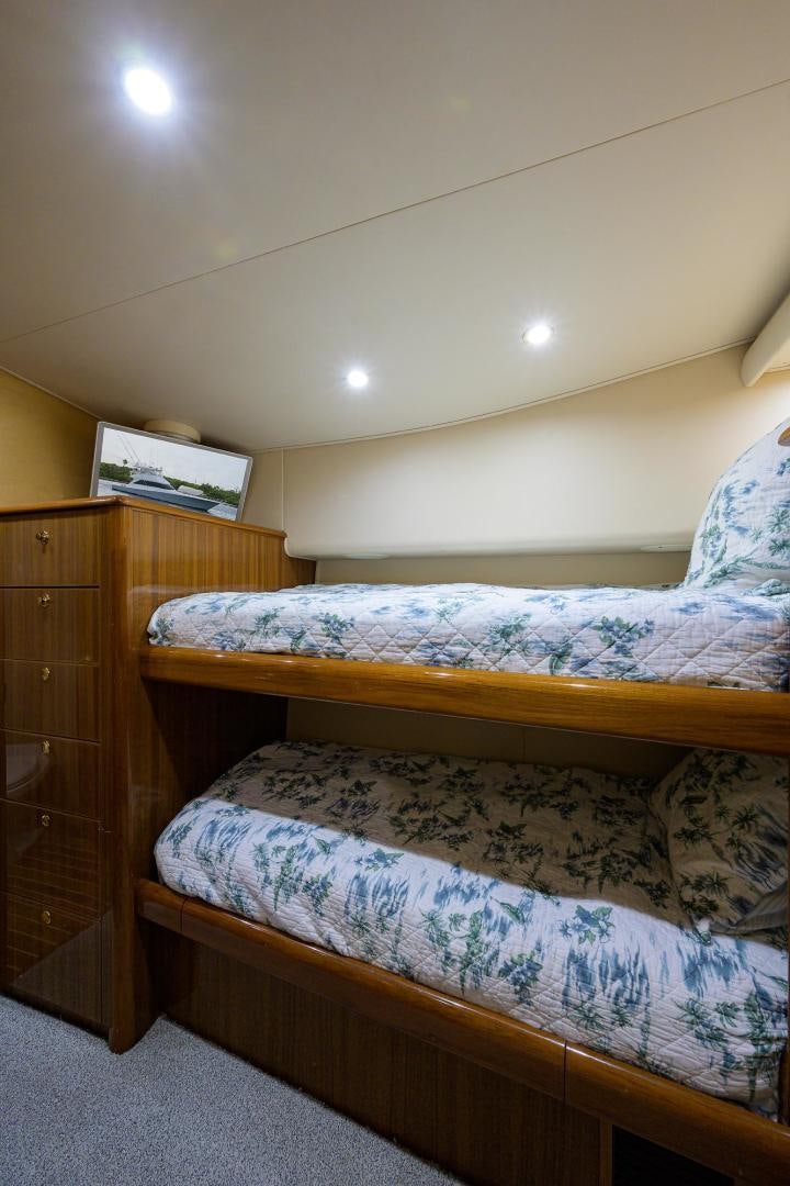 a bedroom with a bed and a dresser aboard LA LADY Yacht for Sale