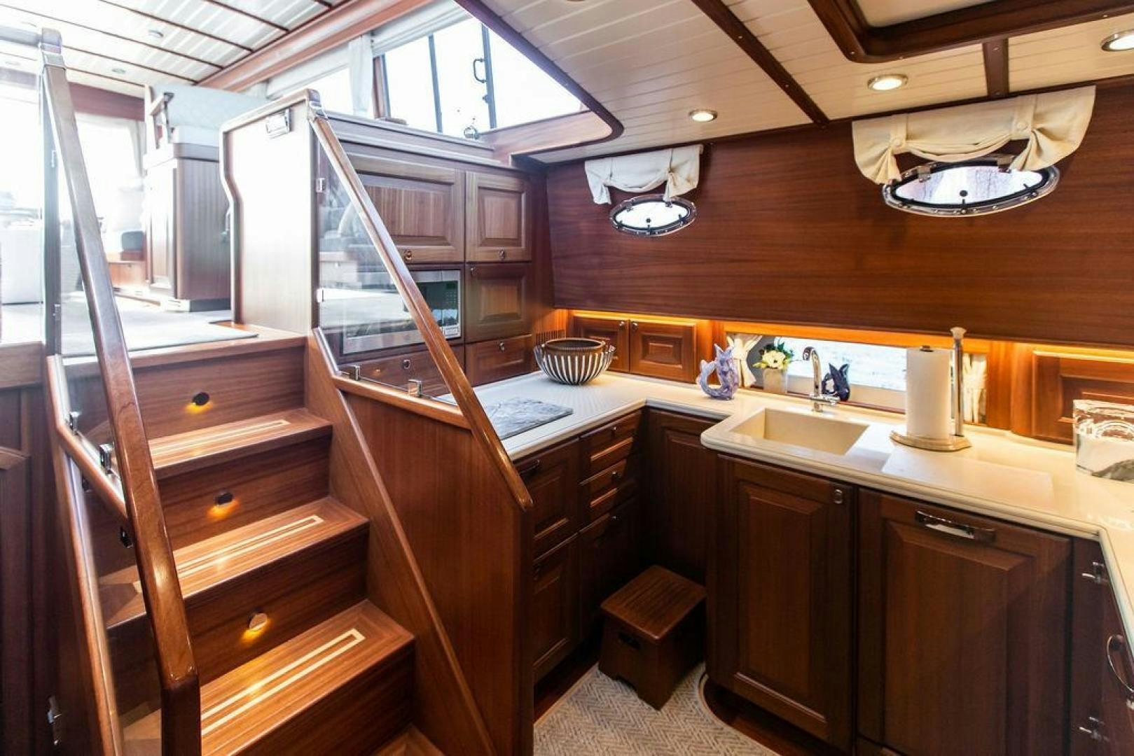 a kitchen with wooden cabinets aboard JESSICA Yacht for Sale