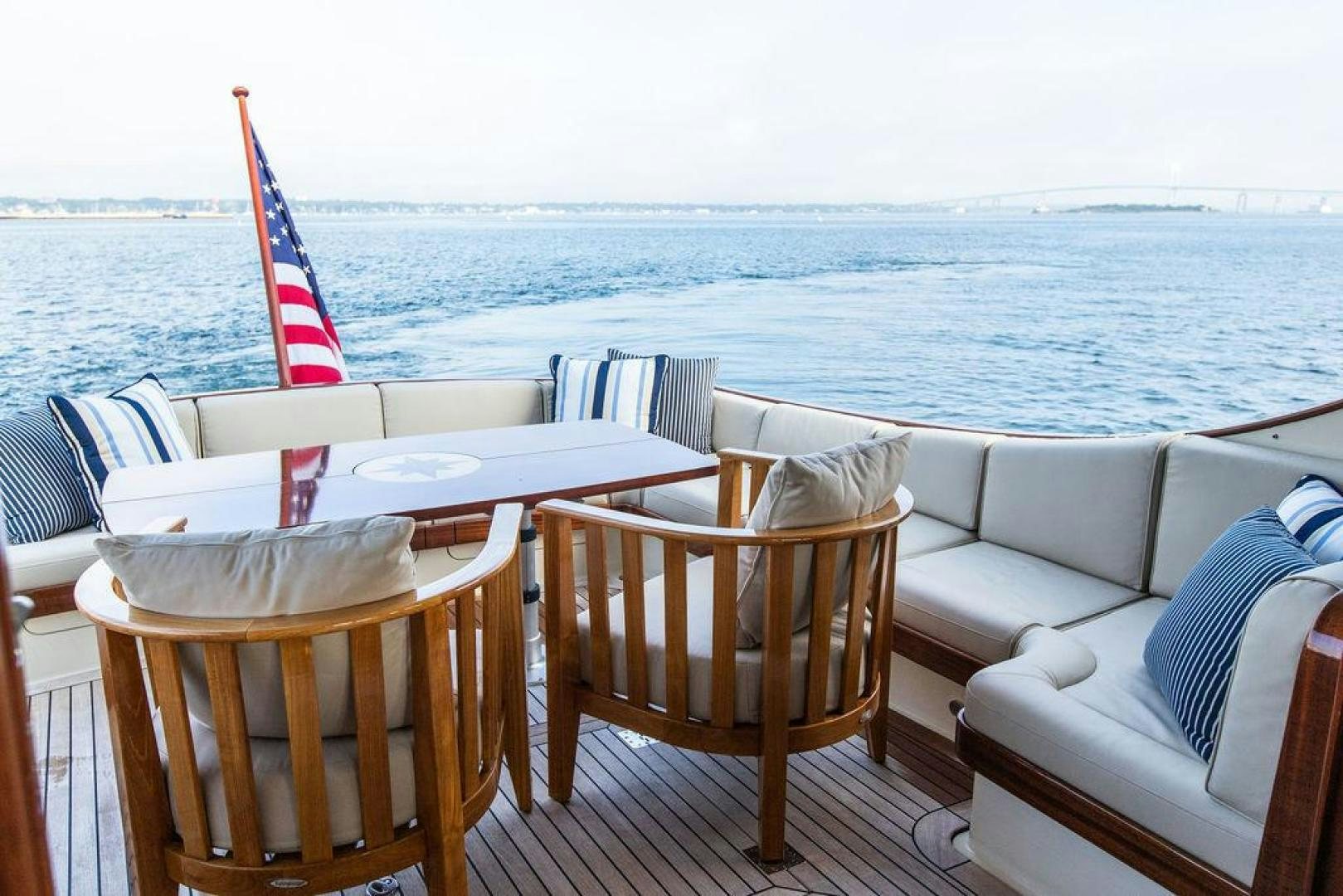 a table and chairs on a deck overlooking a body of water aboard JESSICA Yacht for Sale
