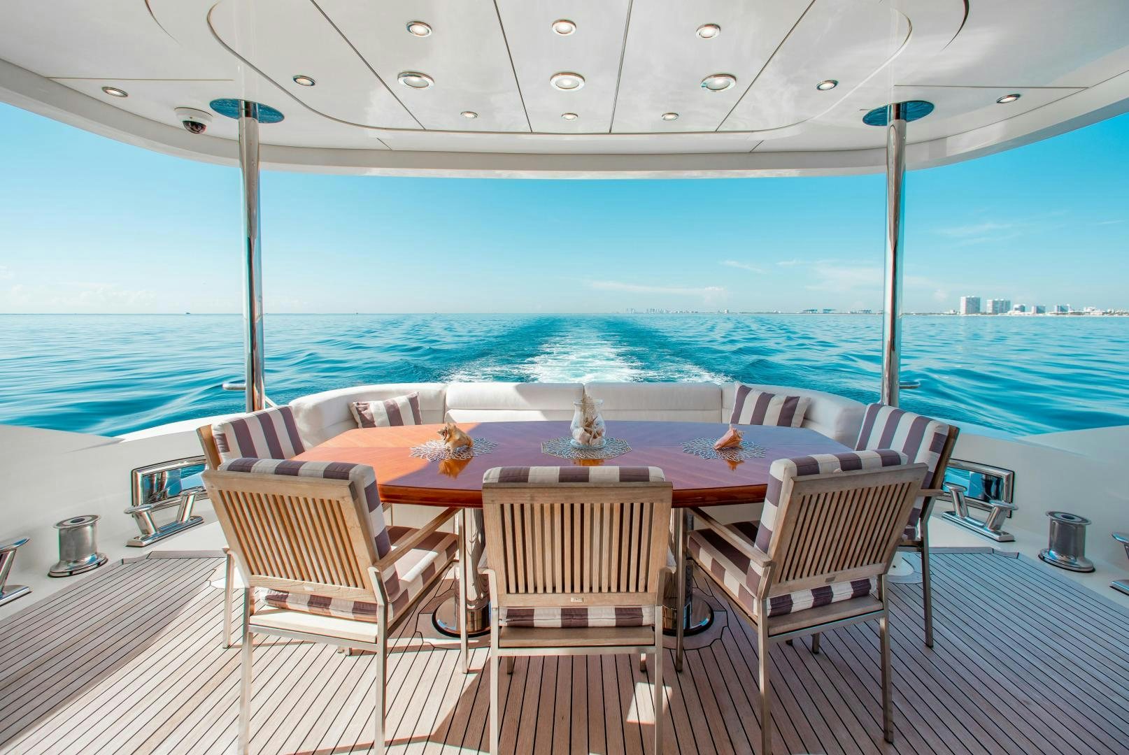 a table and chairs on a deck overlooking the ocean aboard BLACKSHEEP Yacht for Sale