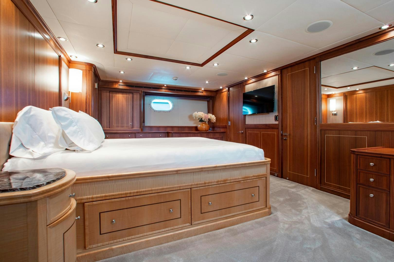 a bedroom with a bed and a dresser aboard BLACKSHEEP Yacht for Sale