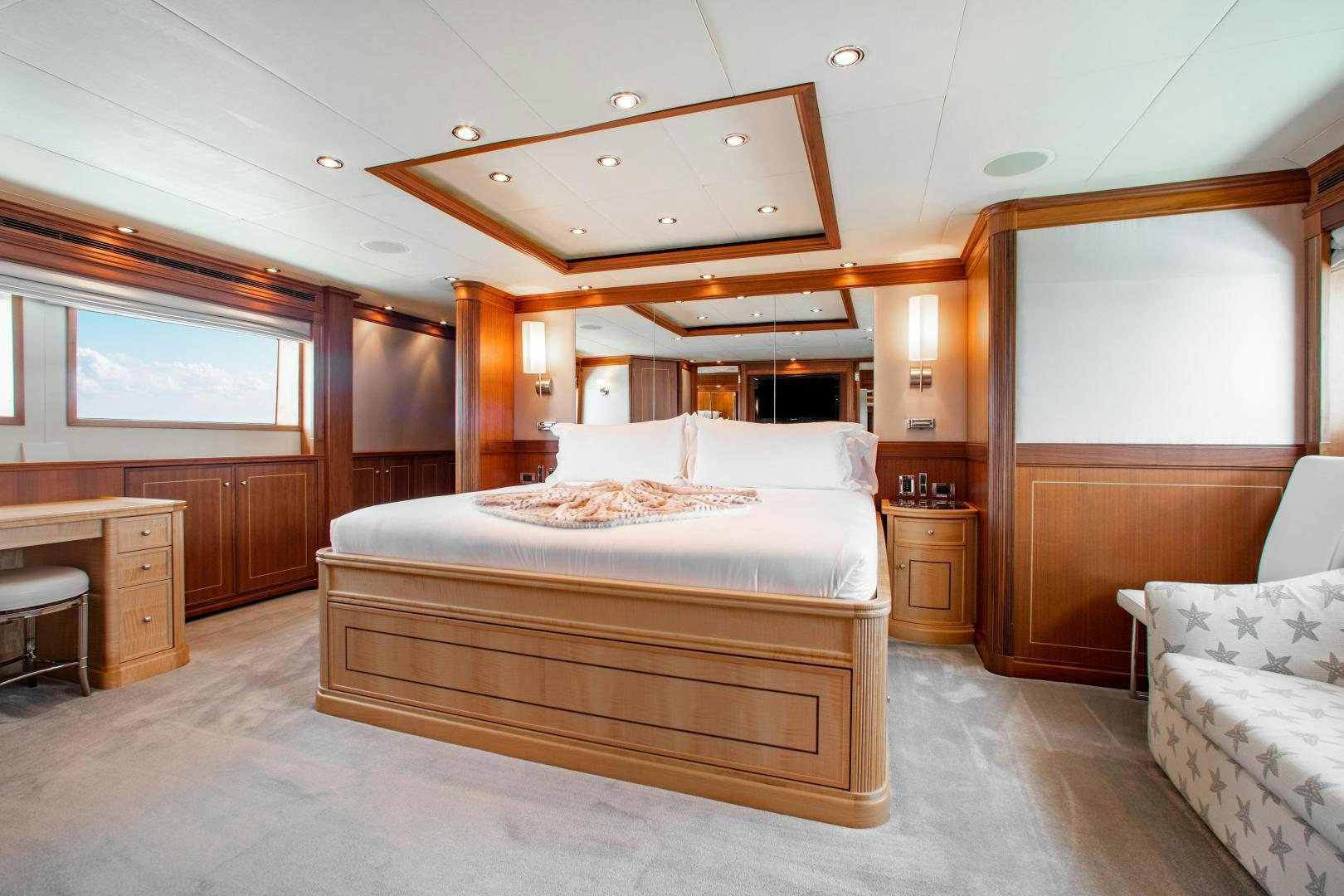 a bedroom with a bed and a desk aboard BLACKSHEEP Yacht for Sale