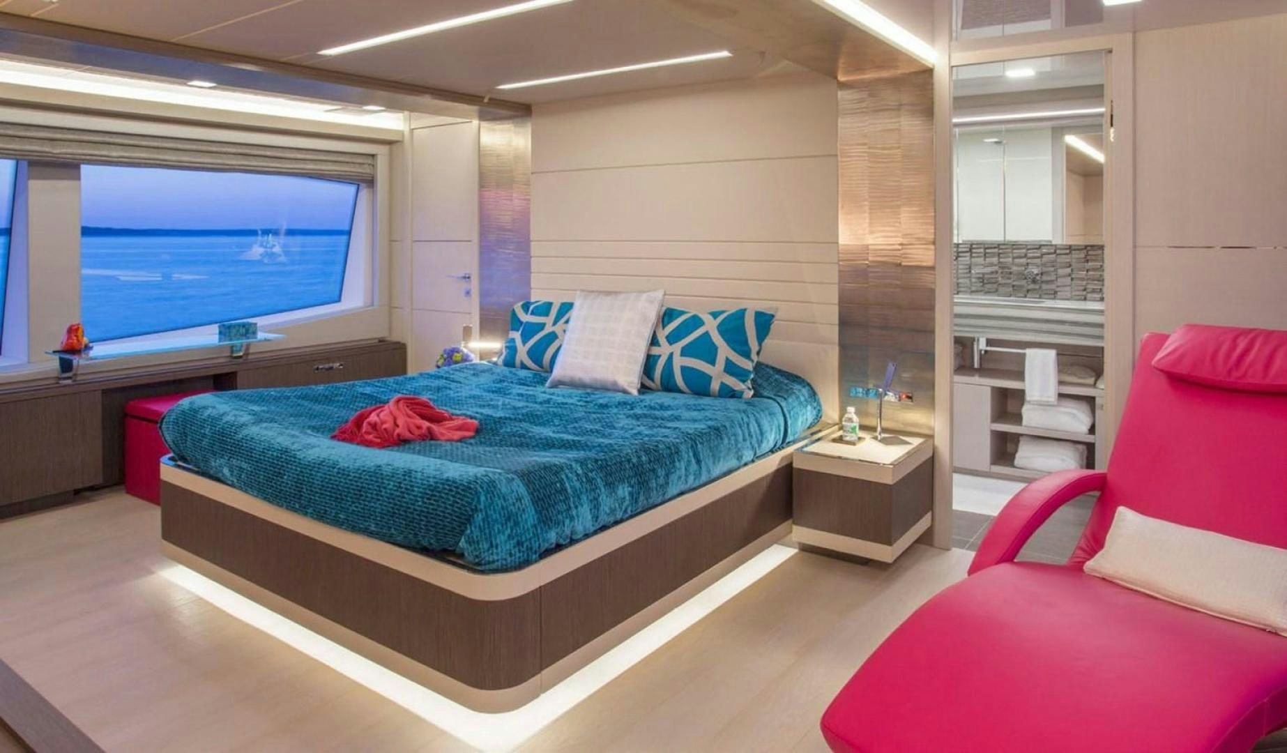 a bedroom with a bed and a red couch aboard ALANDREA Yacht for Sale