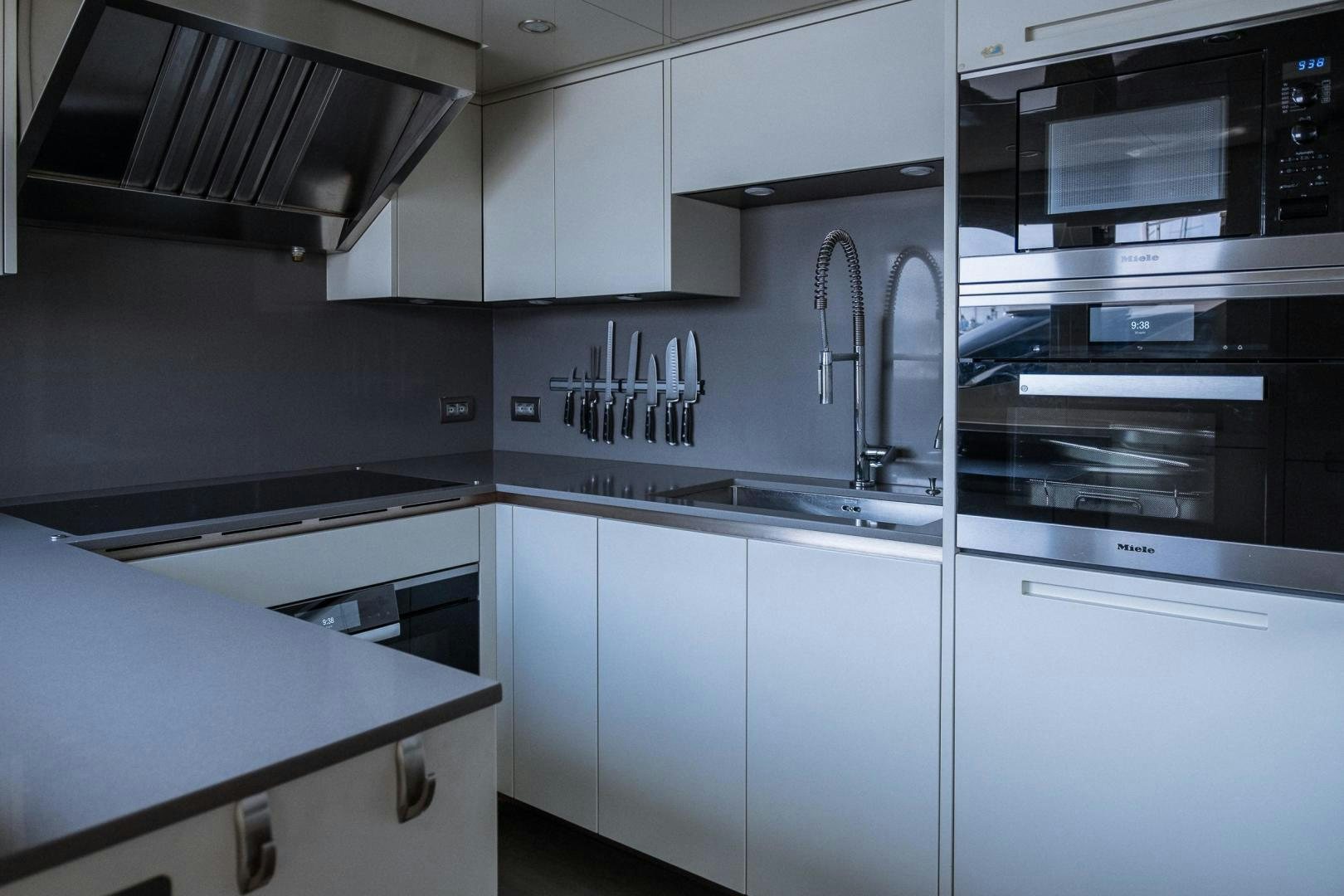 a kitchen with white cabinets aboard AKAR XIII Yacht for Sale
