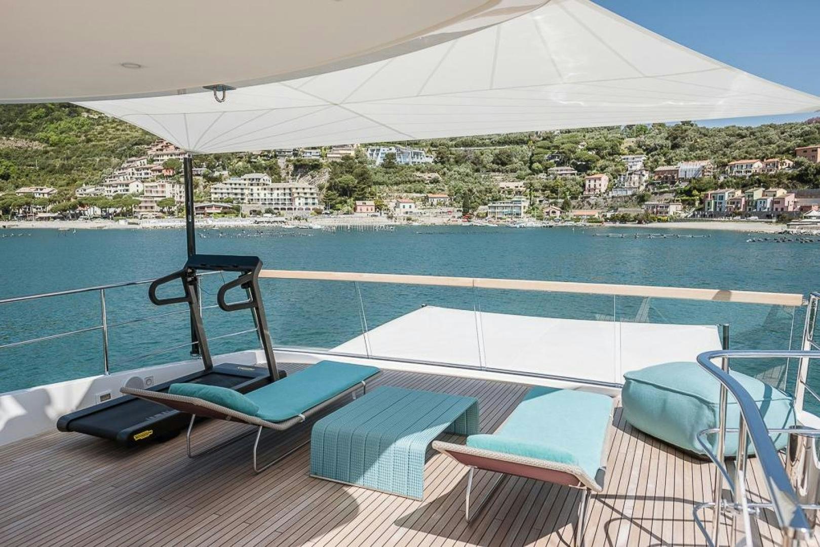 a pool with a laptop and a phone on a deck overlooking a city aboard AKAR XIII Yacht for Sale