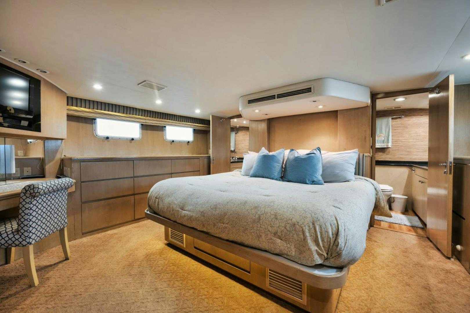 a bedroom with a bed and a television aboard HATT'S OFF Yacht for Sale