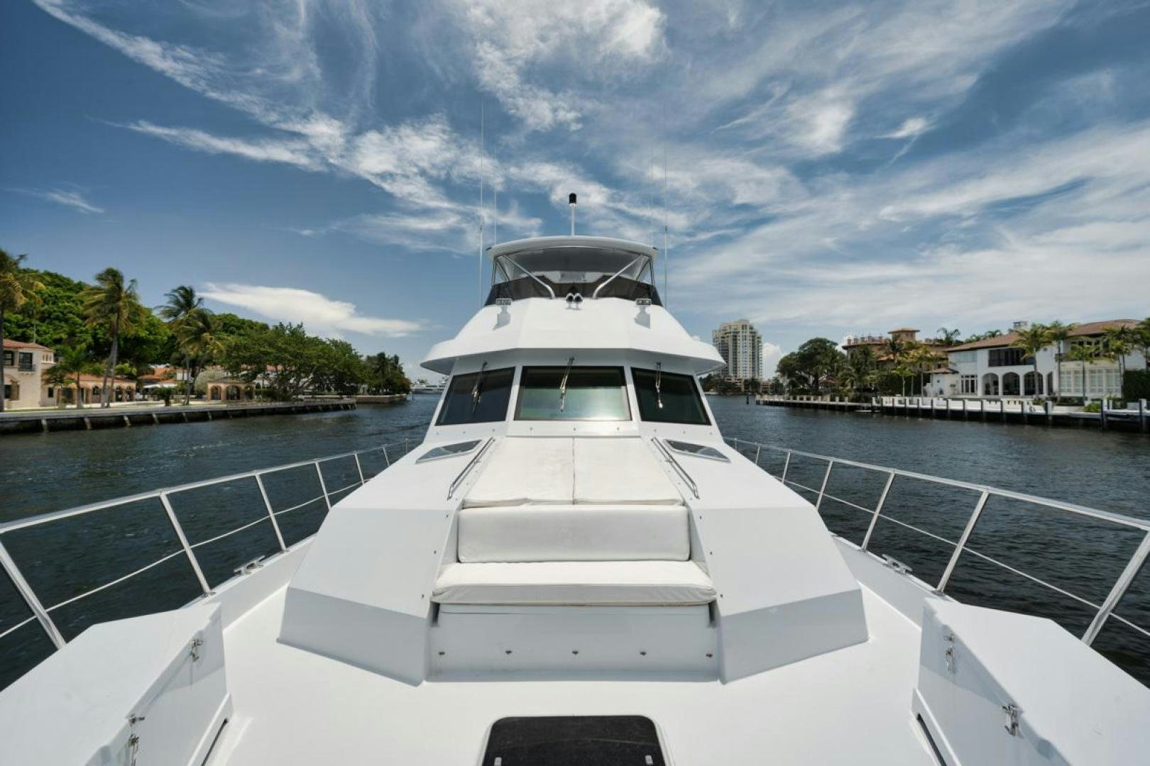 a white yacht in a harbor aboard HATT'S OFF Yacht for Sale
