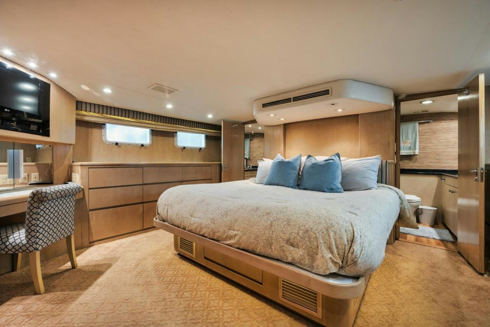 a bedroom with a bed and a television aboard HATT'S OFF Yacht for Sale