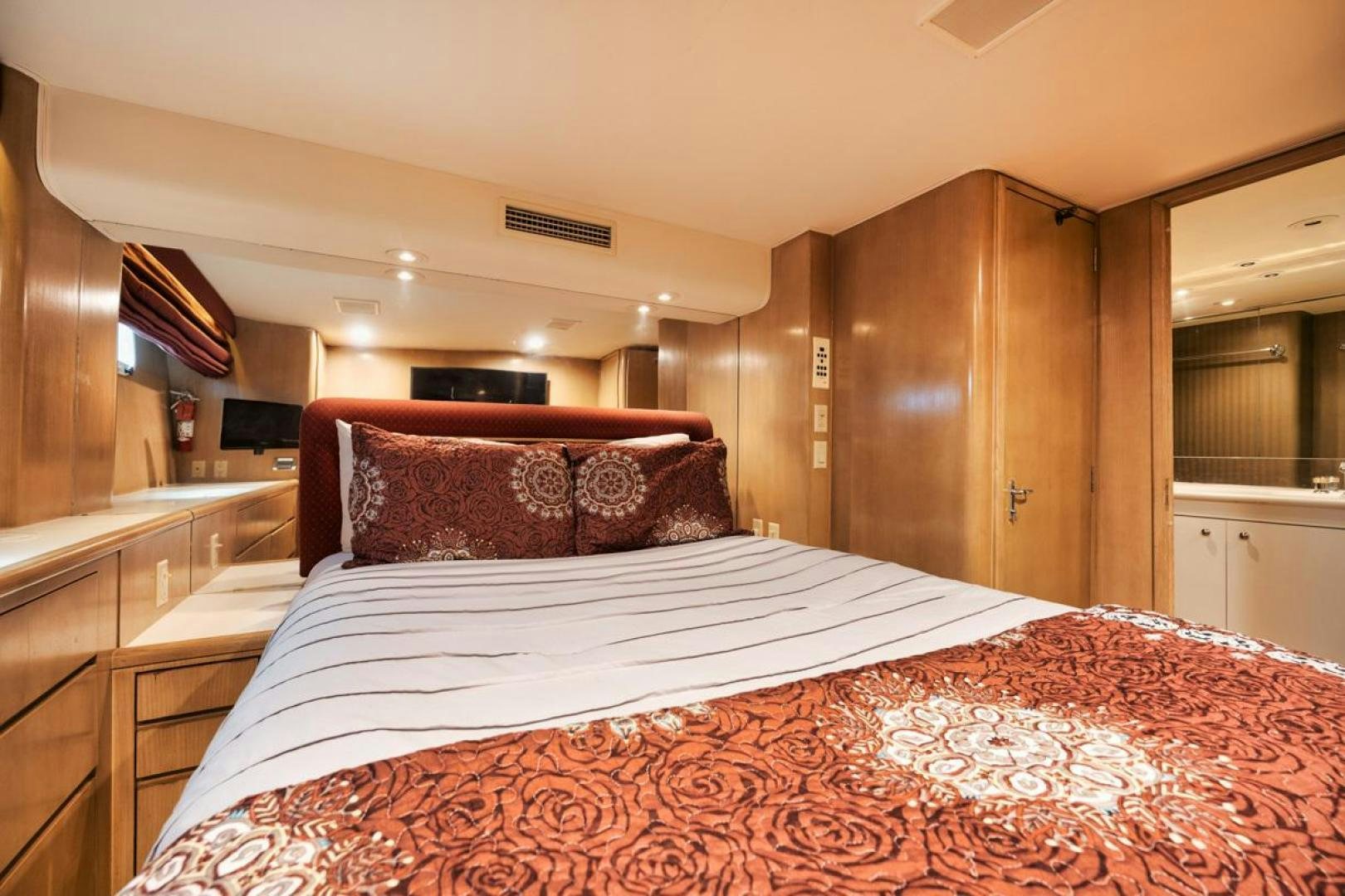 a bed with a red and white comforter aboard HATT'S OFF Yacht for Sale