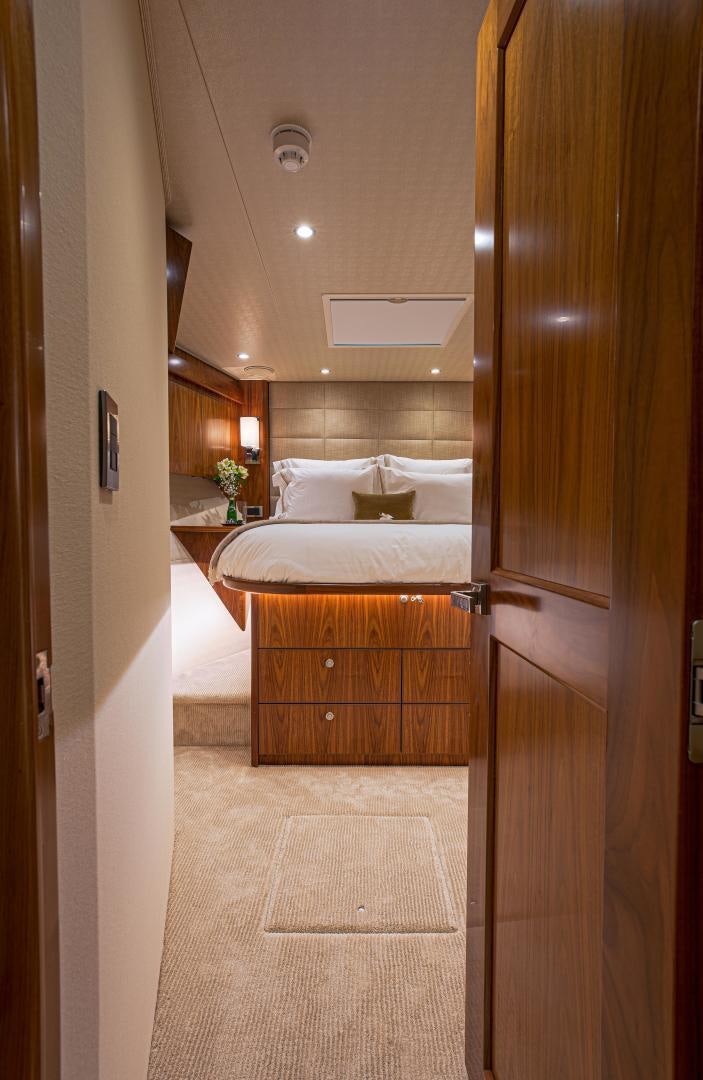 a bedroom with a bed and a wood door aboard SPECULATOR Yacht for Sale