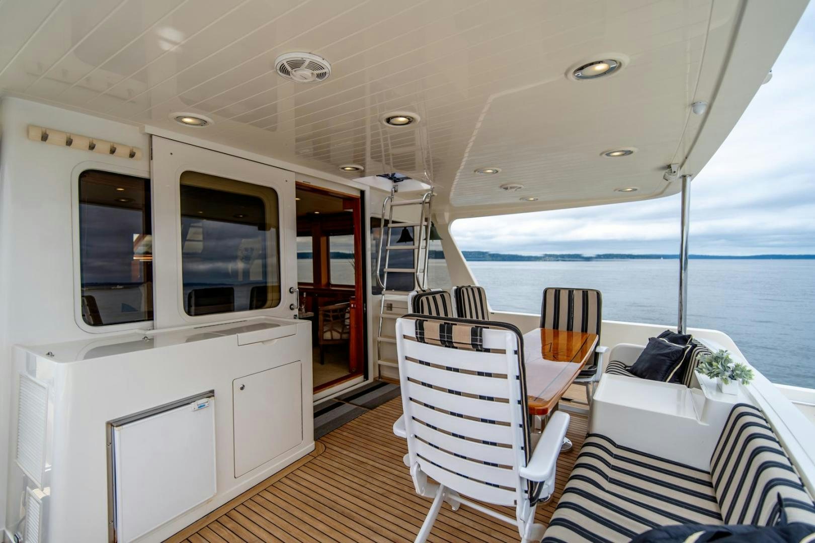 a boat with a table and chairs on the deck aboard HONORE Yacht for Sale