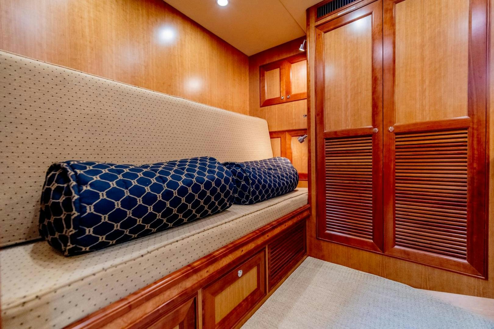 a bed with blue and white sheets aboard HONORE Yacht for Sale