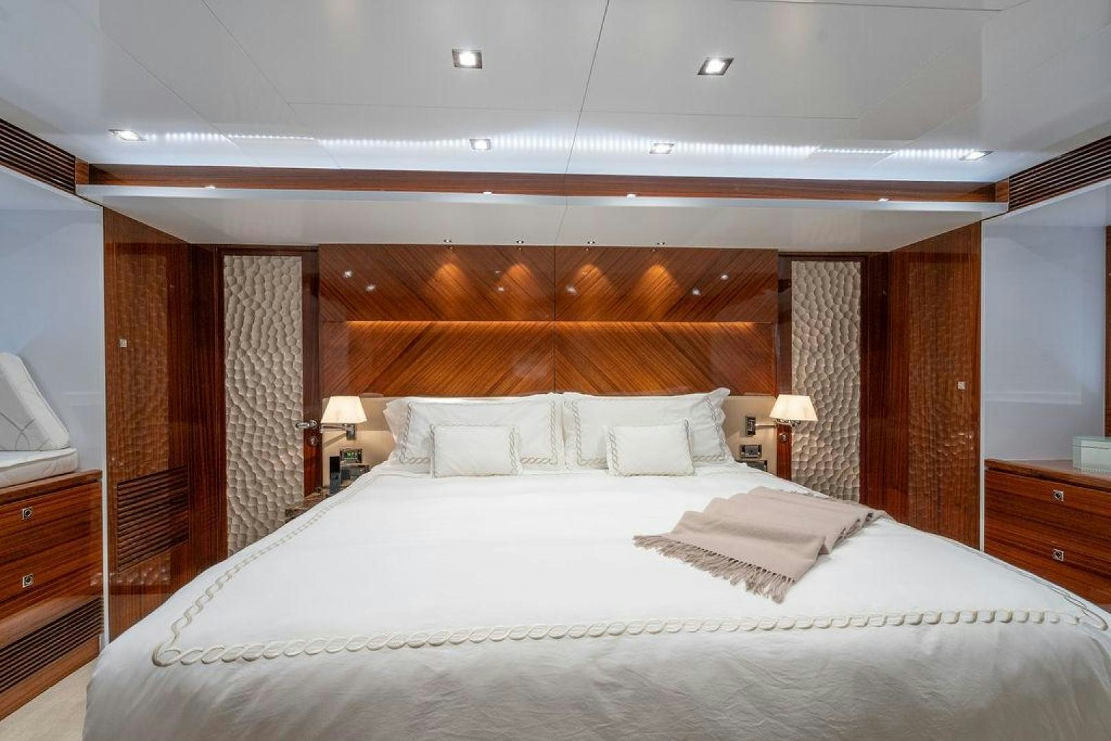 a large bed with a white comforter and a wood headboard aboard AQUA LIFE Yacht for Sale