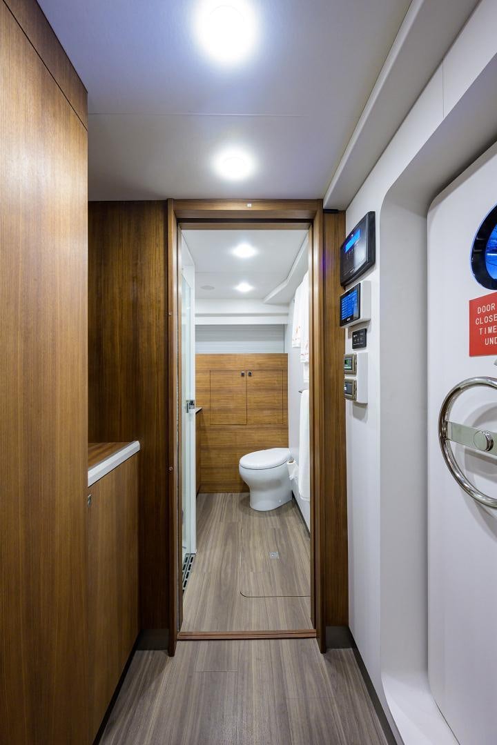 a bathroom with a toilet and a hallway aboard MY 3 GALS Yacht for Sale
