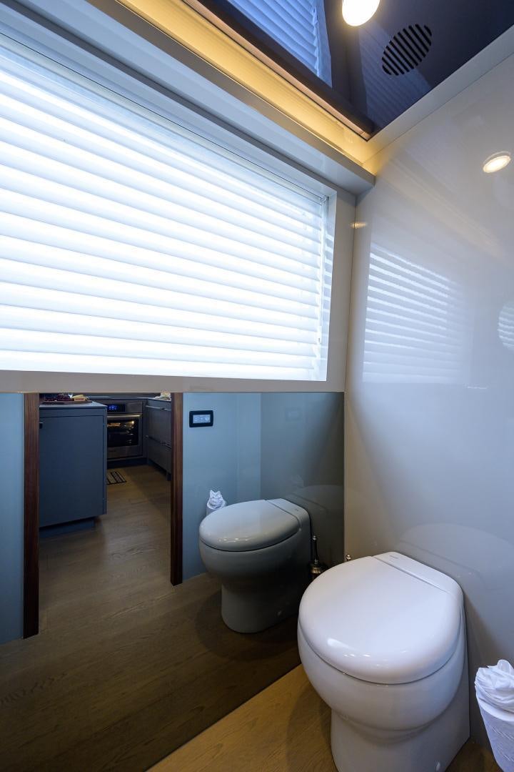 a bathroom with a toilet and a window aboard MY 3 GALS Yacht for Sale