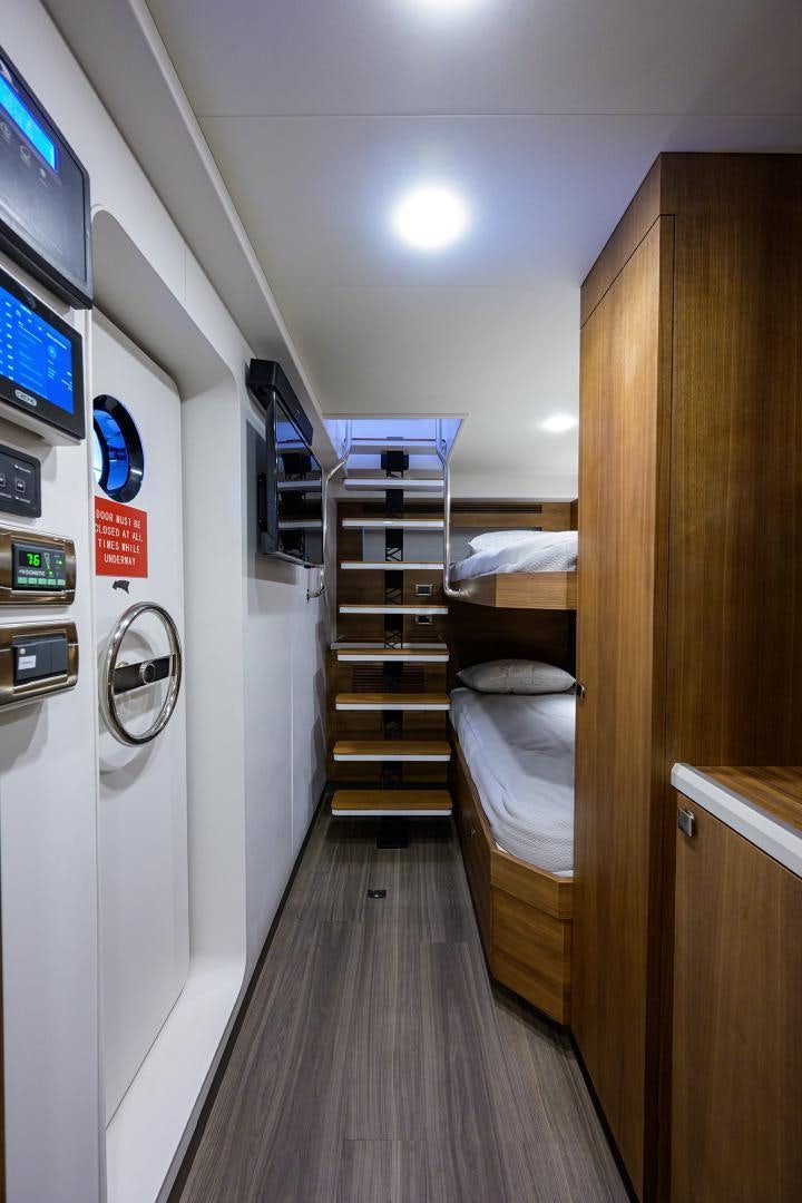 a room with a bed and a shelf with a shelf and a shelf with electronic devices aboard MY 3 GALS Yacht for Sale