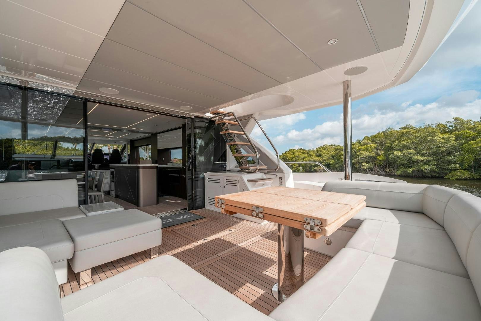 a room with a table and couches aboard ONE Yacht for Sale