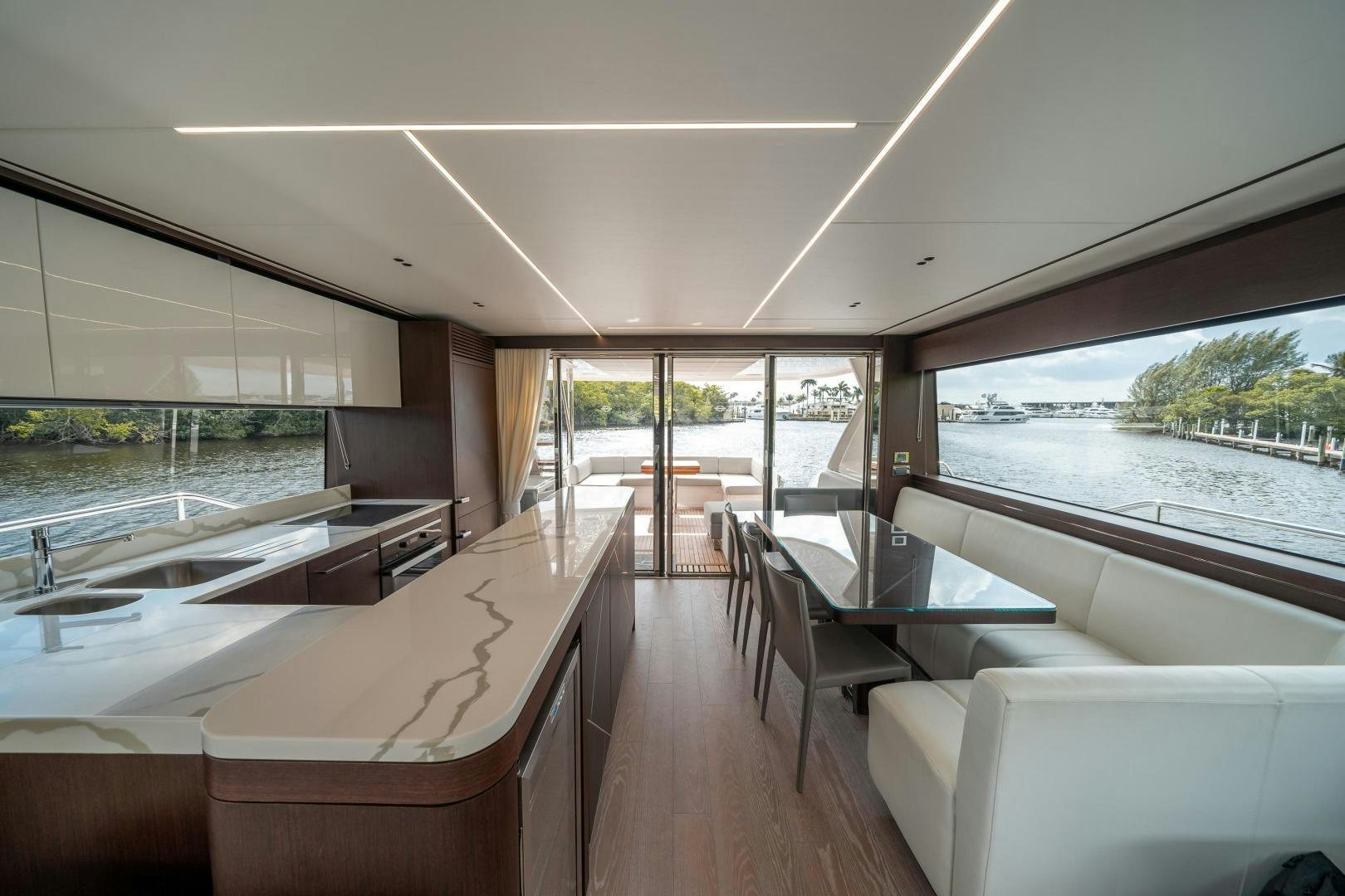 a room with a large window and a table with chairs and a view of the water aboard ONE Yacht for Sale