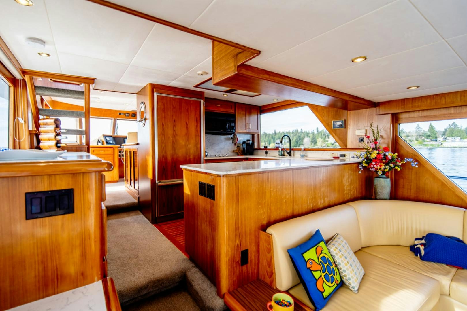 a living room with a couch and a kitchen aboard the happy boat Yacht for Sale