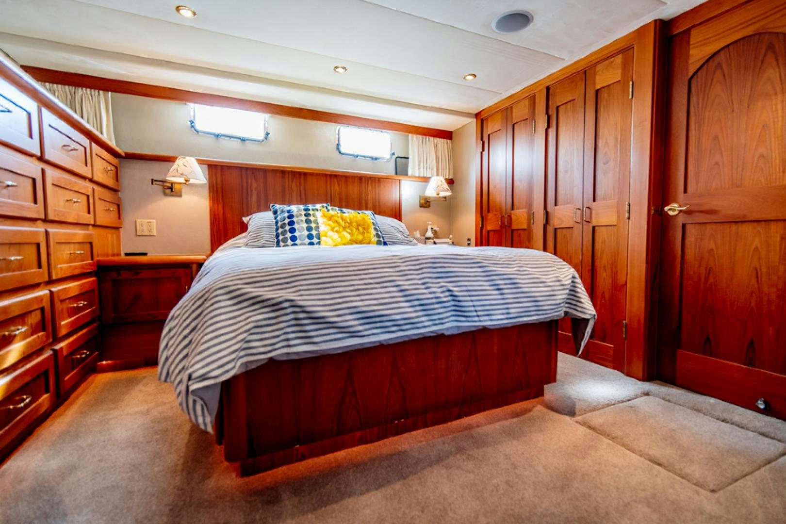 a bedroom with a bed and cabinets aboard the happy boat Yacht for Sale