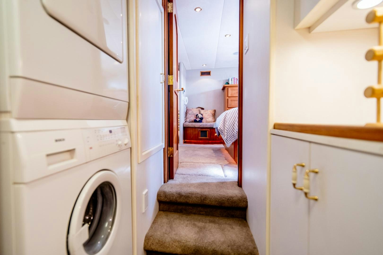 a room with a washing machine and a door aboard the happy boat Yacht for Sale