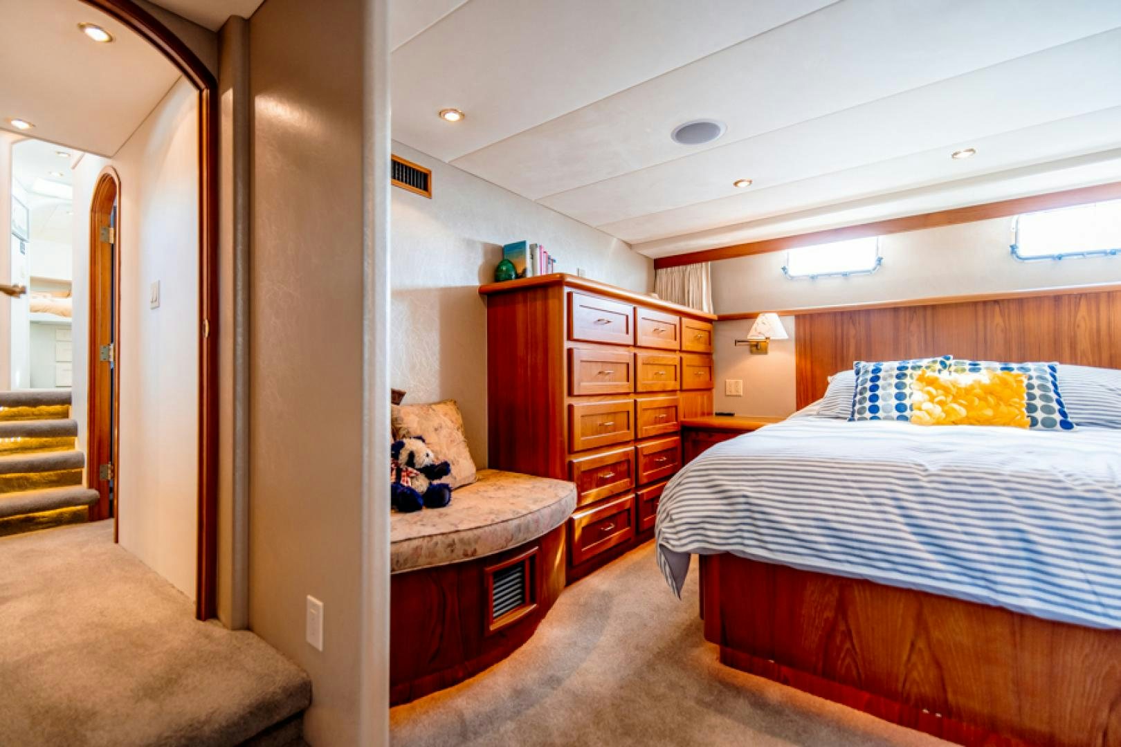 a bedroom with a bed and a dresser aboard the happy boat Yacht for Sale