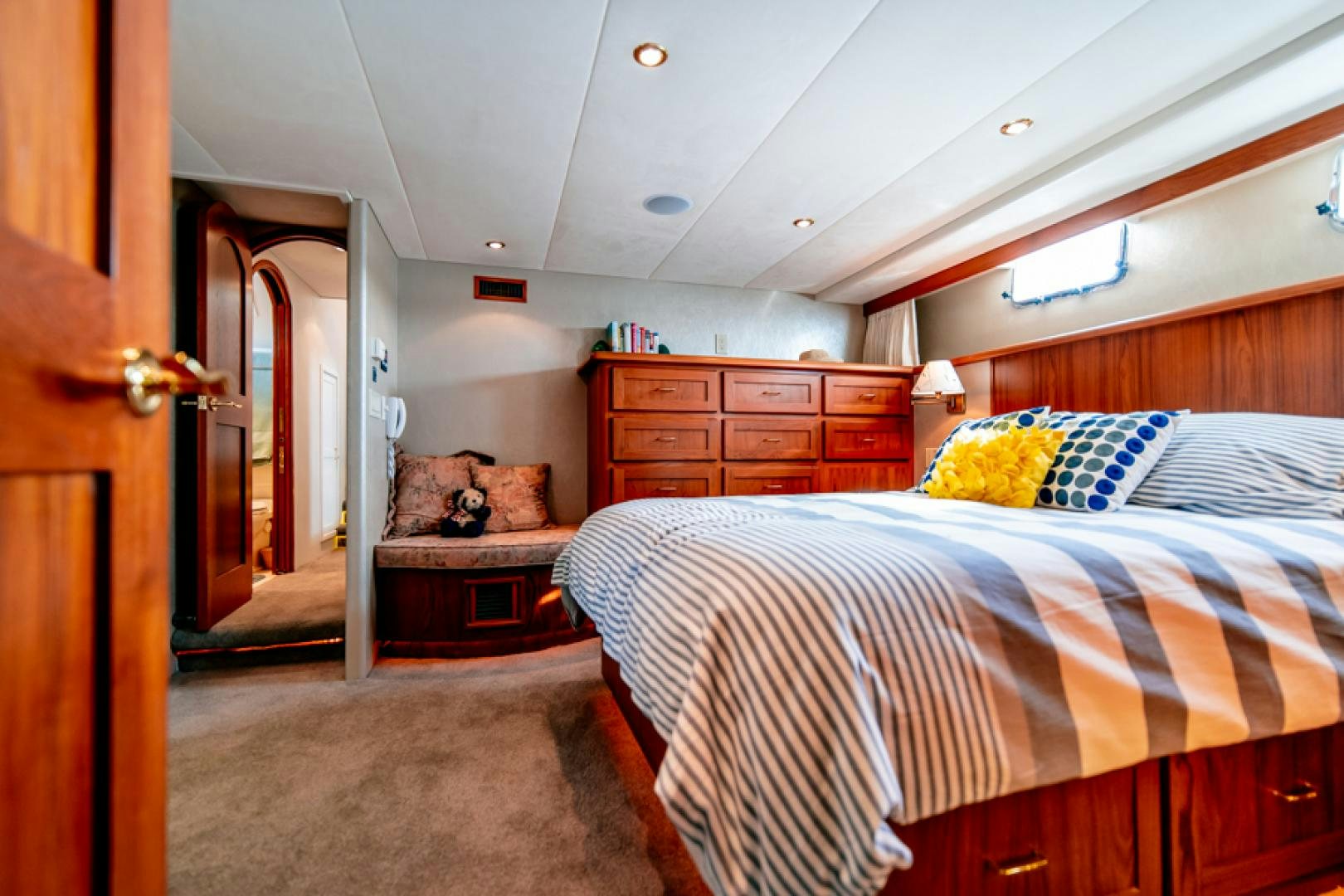 a bedroom with a bed and dresser aboard the happy boat Yacht for Sale