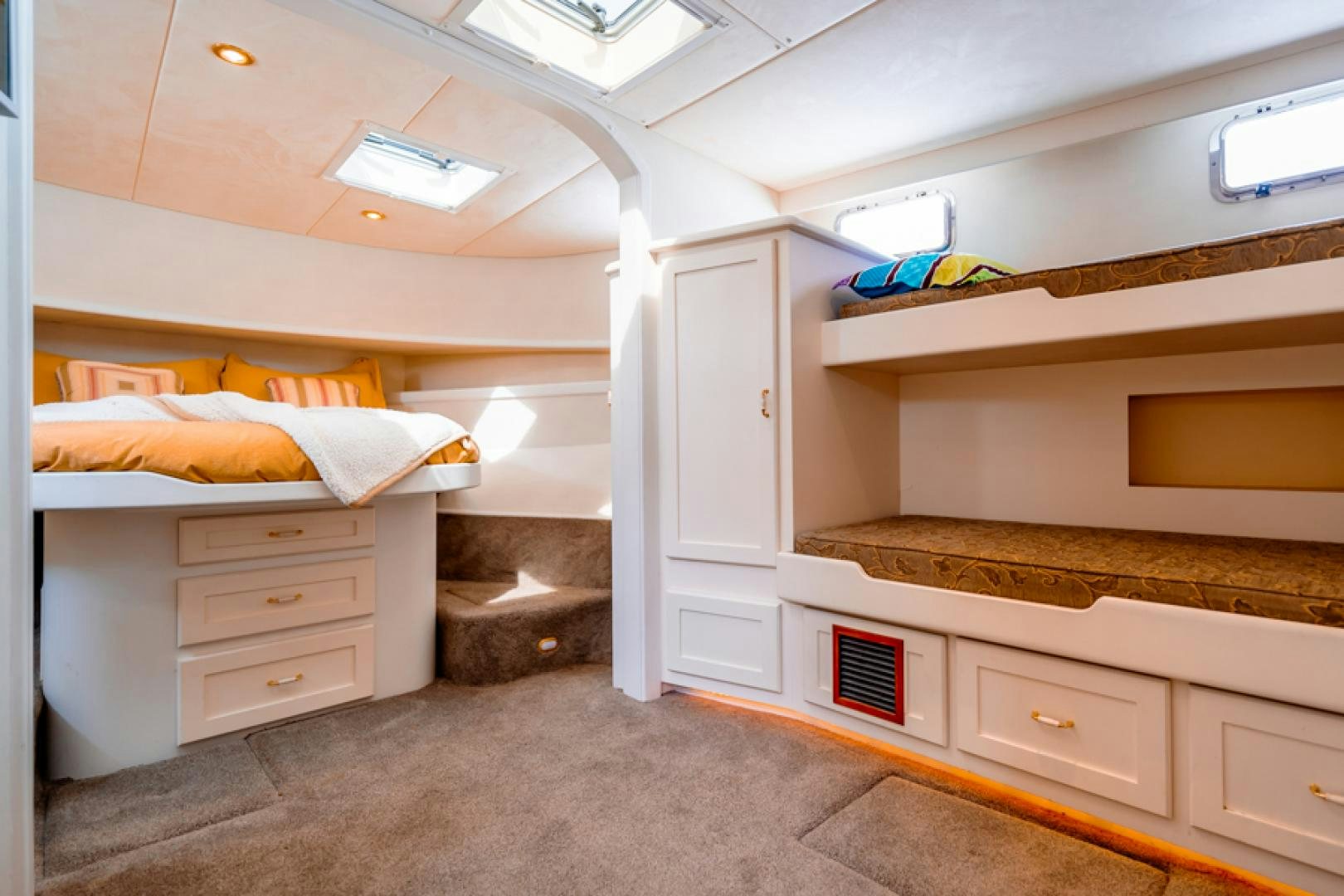a room with a bed and a dresser aboard the happy boat Yacht for Sale