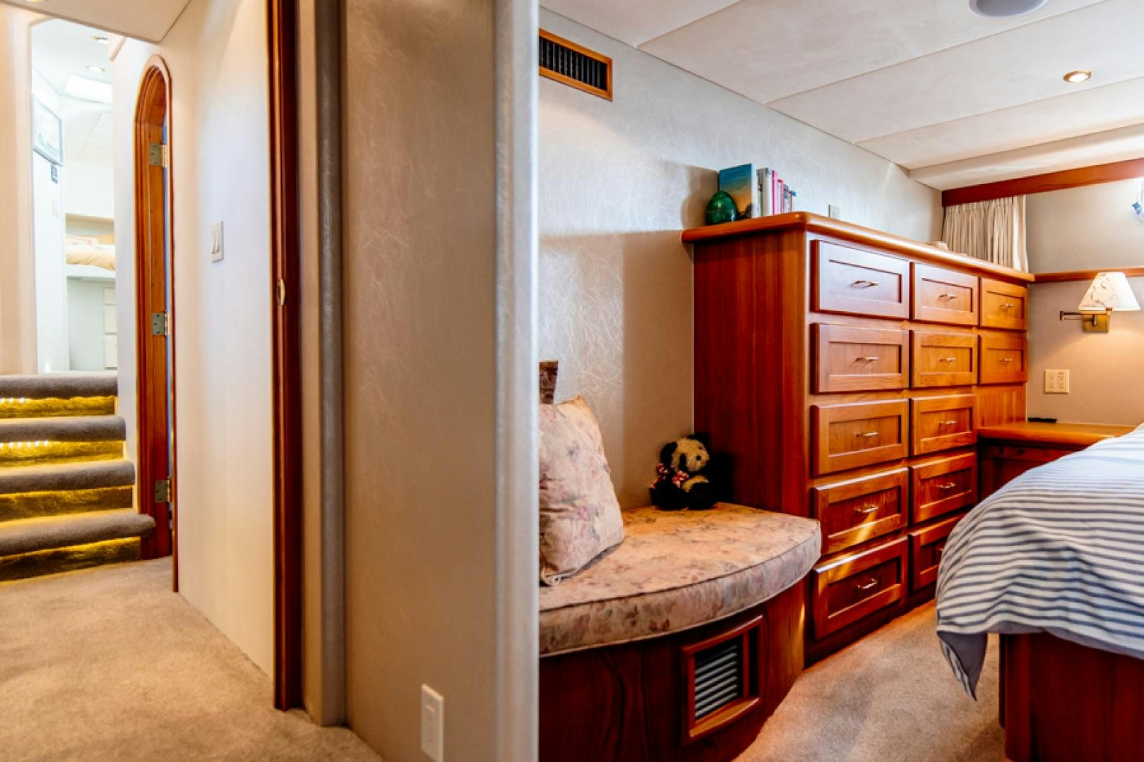 a bedroom with a bed and a dresser aboard the happy boat Yacht for Sale