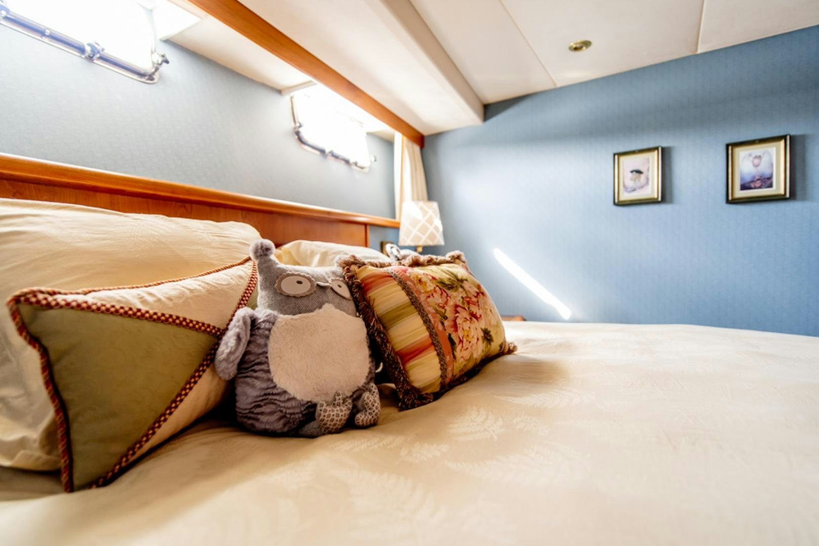 a teddy bear lays on a bed aboard the happy boat Yacht for Sale