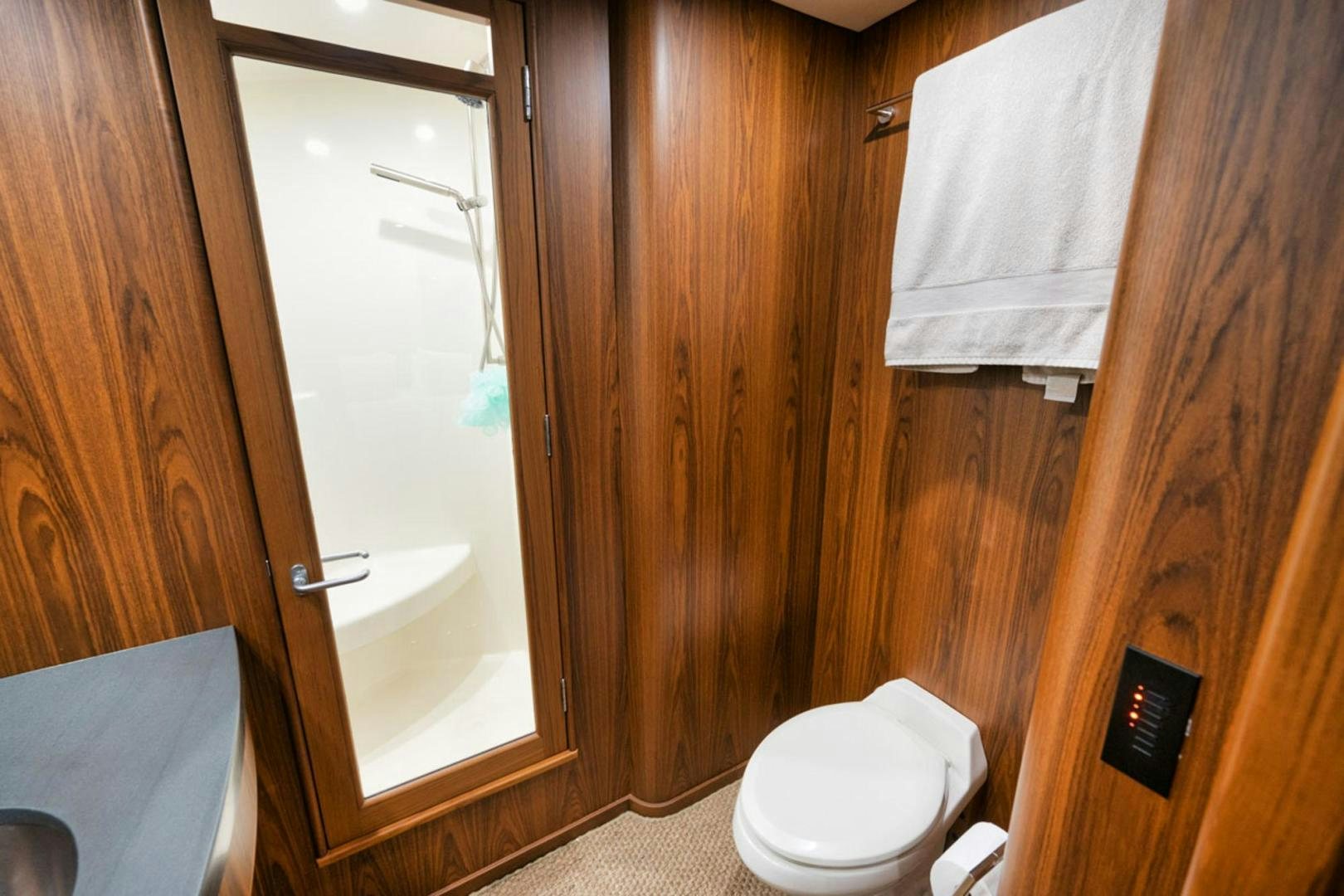 a bathroom with a toilet and a wooden door aboard SIR REEL Yacht for Sale