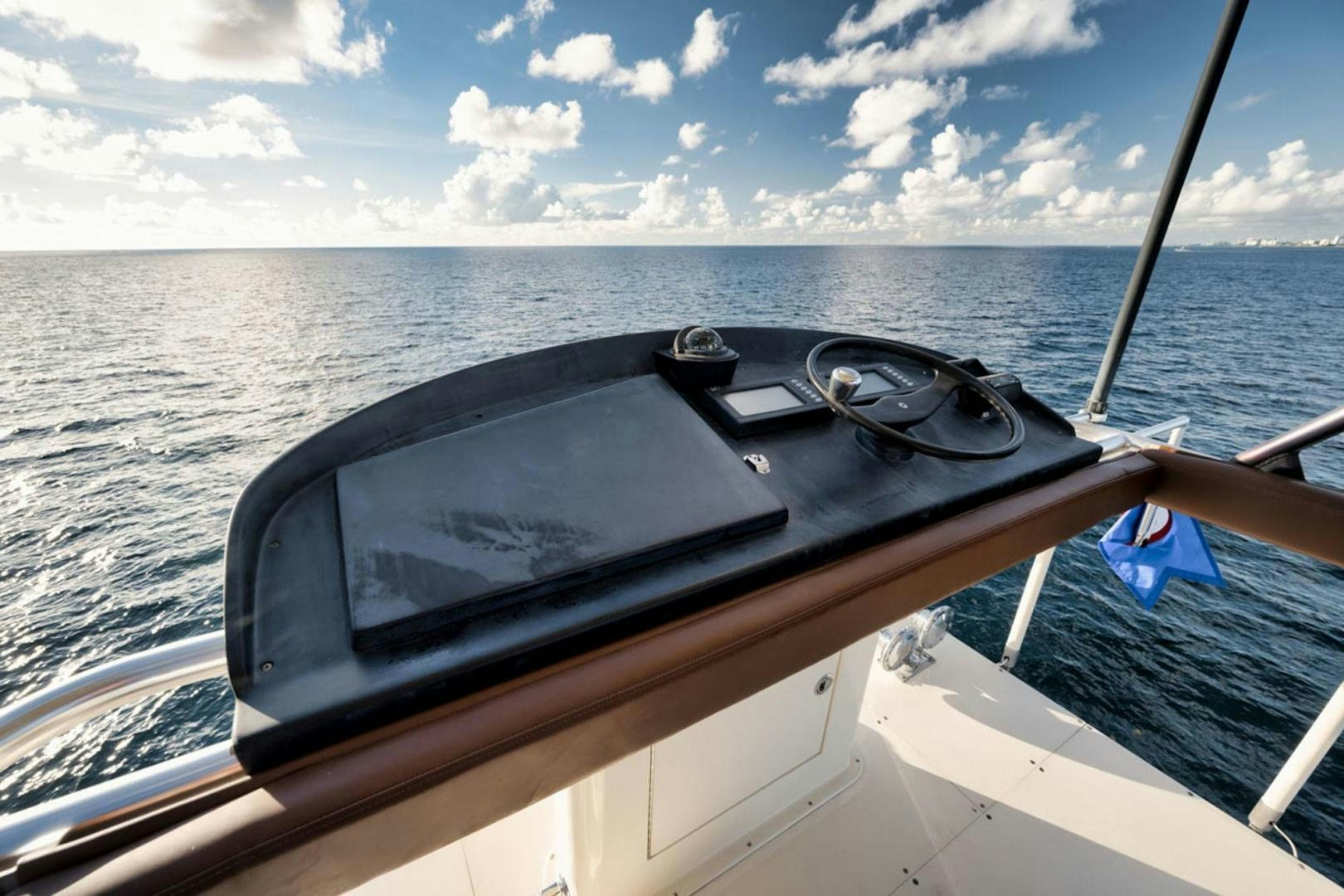 a boat with a steering wheel and a view of the city below aboard SIR REEL Yacht for Sale