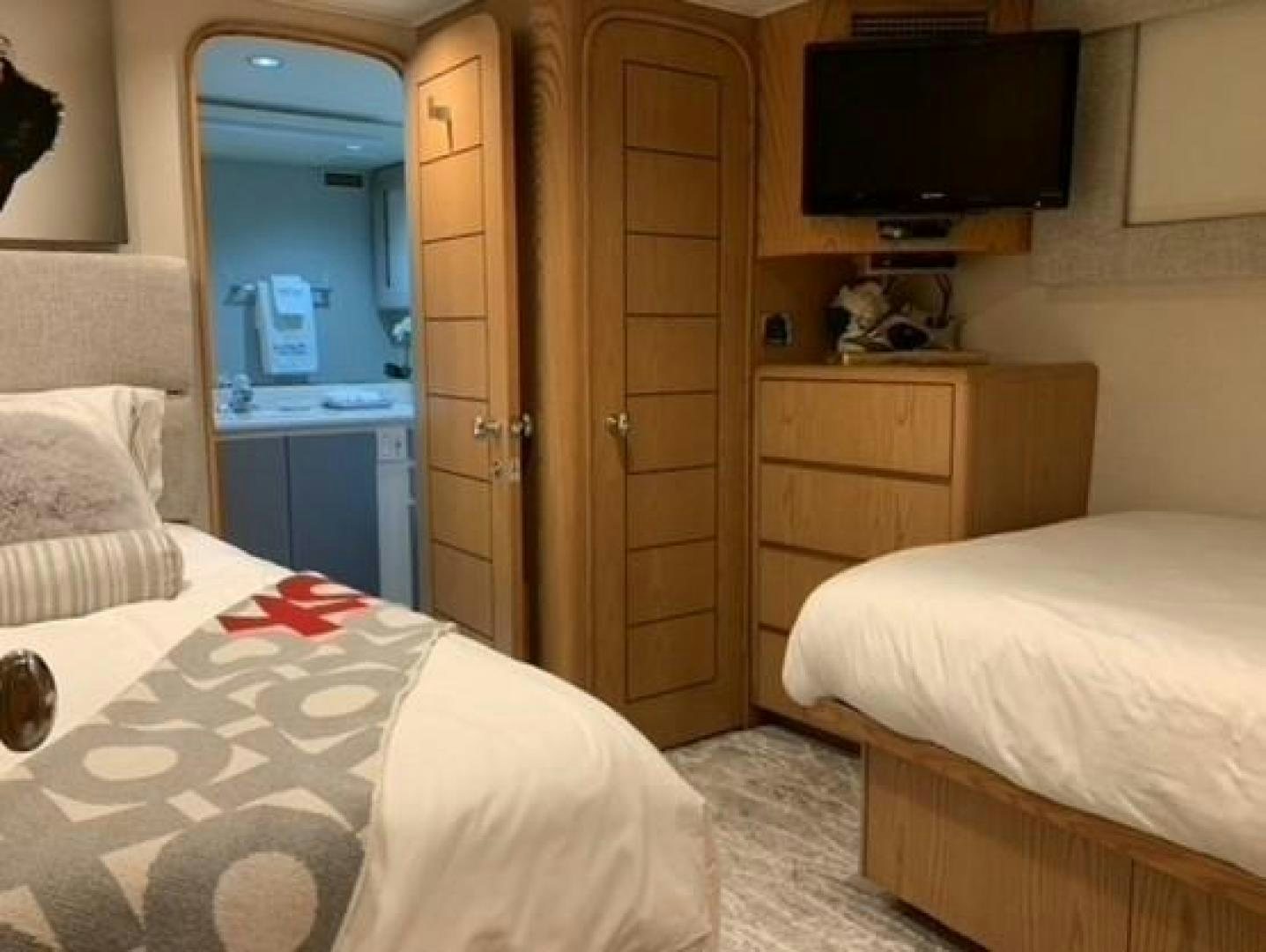 a bedroom with a bed and a television aboard MARGATE Yacht for Charter