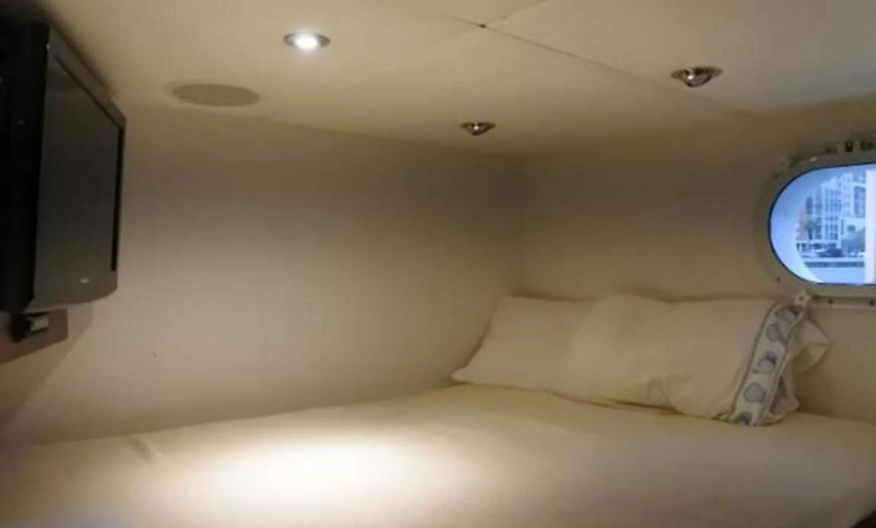 a bed with a television on the wall aboard MY LADY ALASKA Yacht for Sale