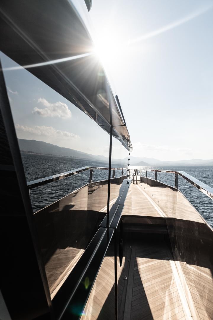 a deck with a railing and a body of water in the background aboard EVADNE ROCK 85 HULL 4 Yacht for Sale